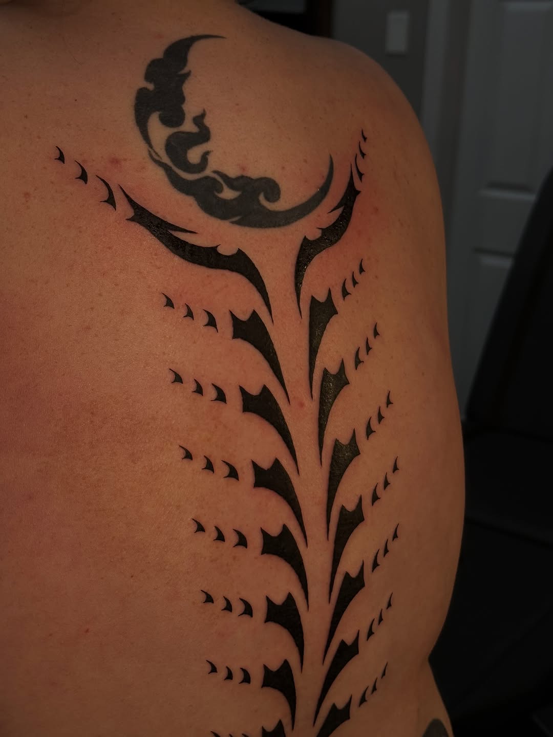Tribal vine with moon blackwork tattoo on the back by 𝔍𝔲𝔩𝔦𝔞, New York, New York