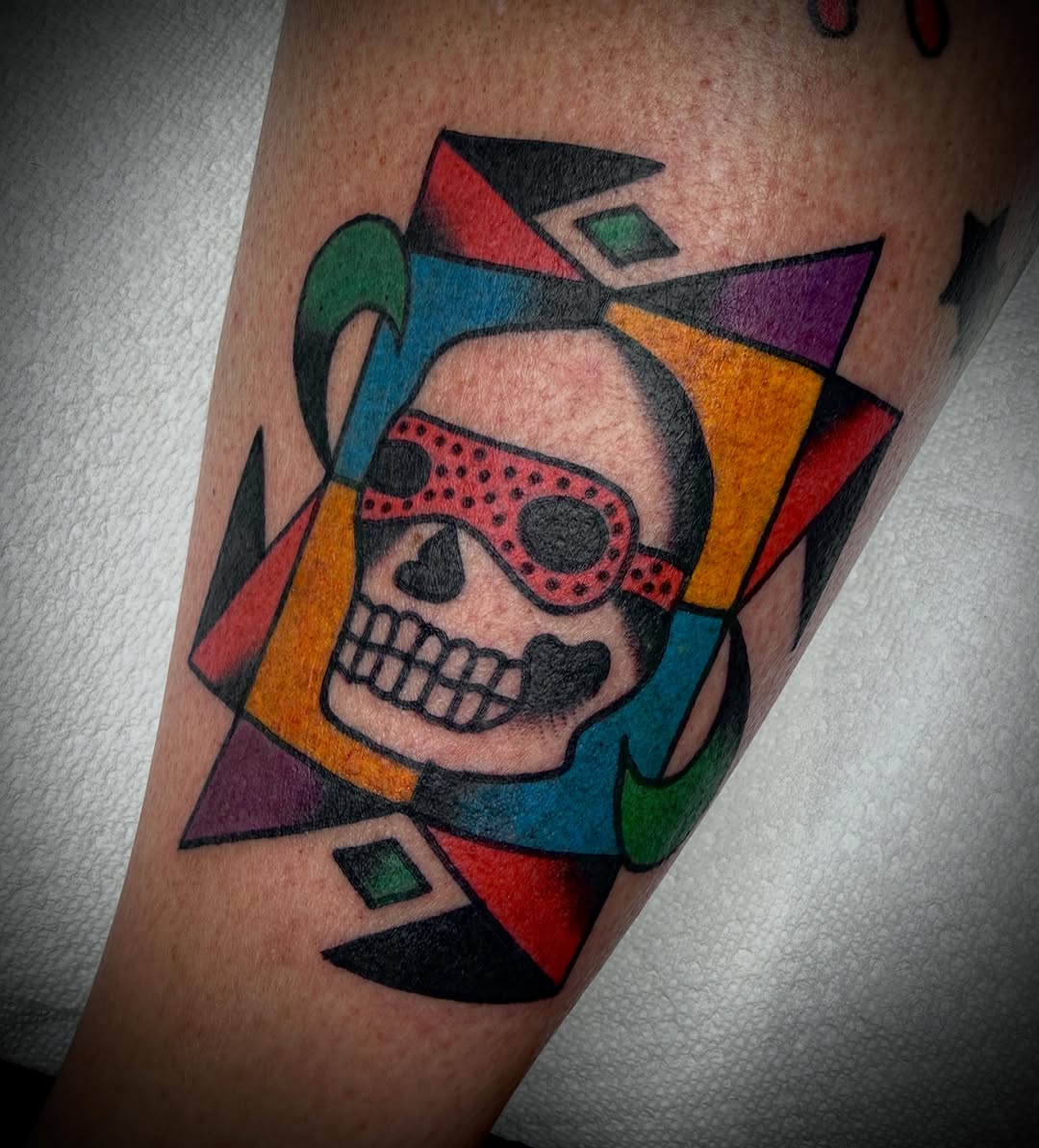 Skull with mask geometric tattoo on the forearm by Tristan Bradshaw