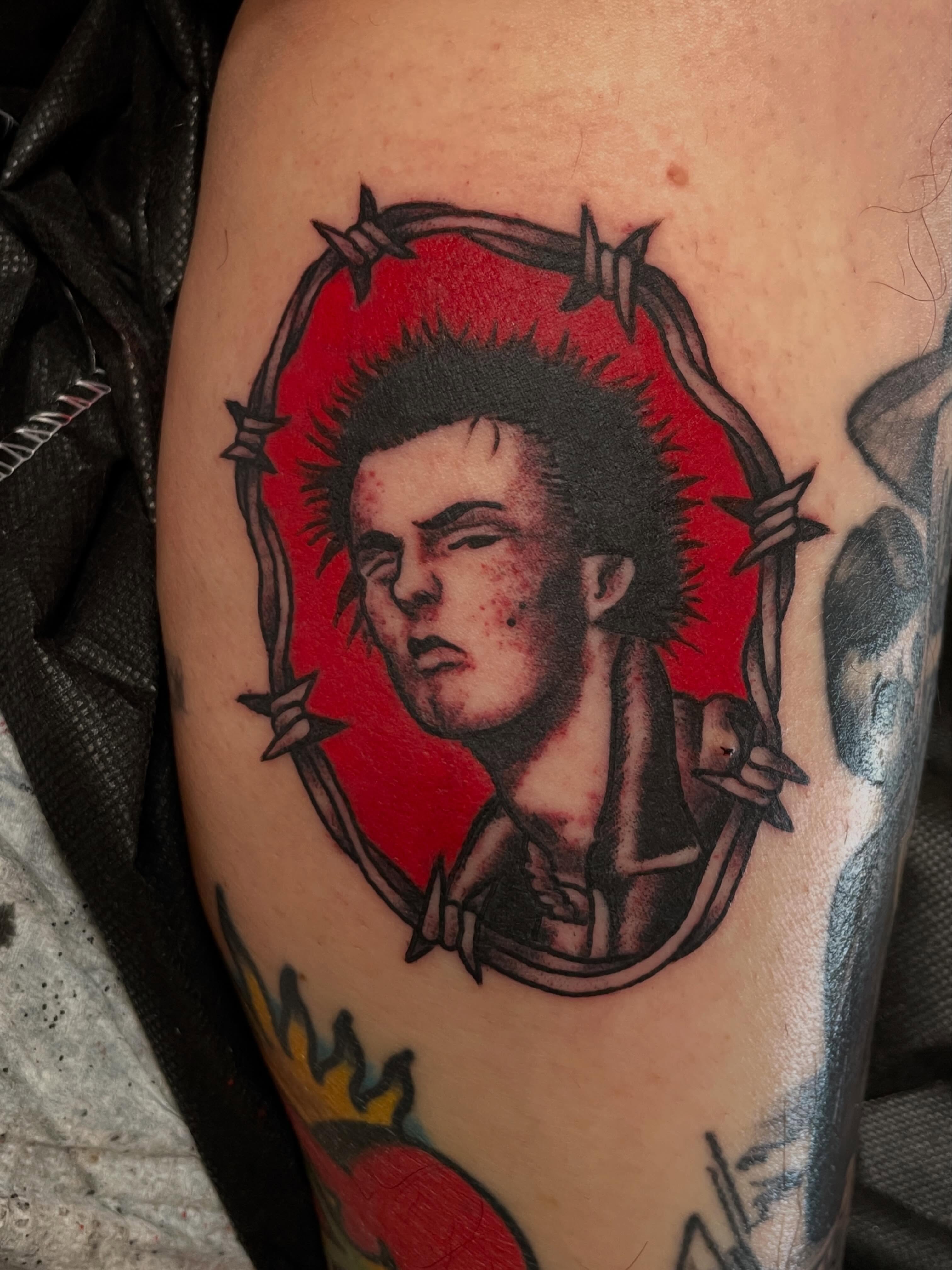 Punk portrait realism tattoo on the forearm by Nick Wallin