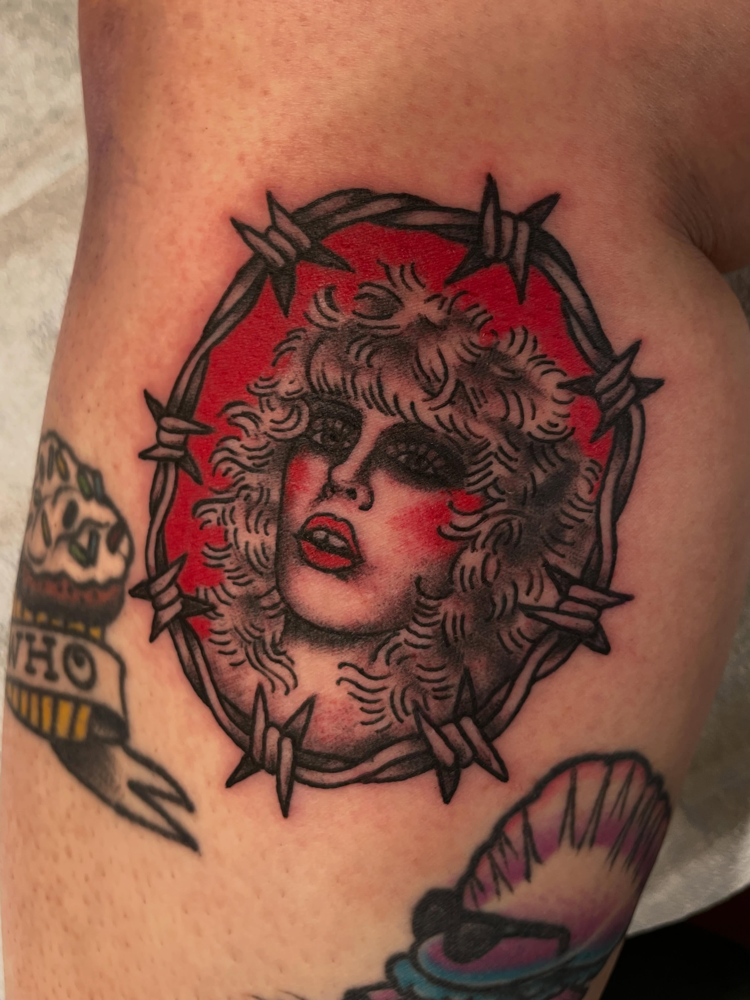 Woman with barbed wire American traditional tattoo on the thigh by Nick Wallin