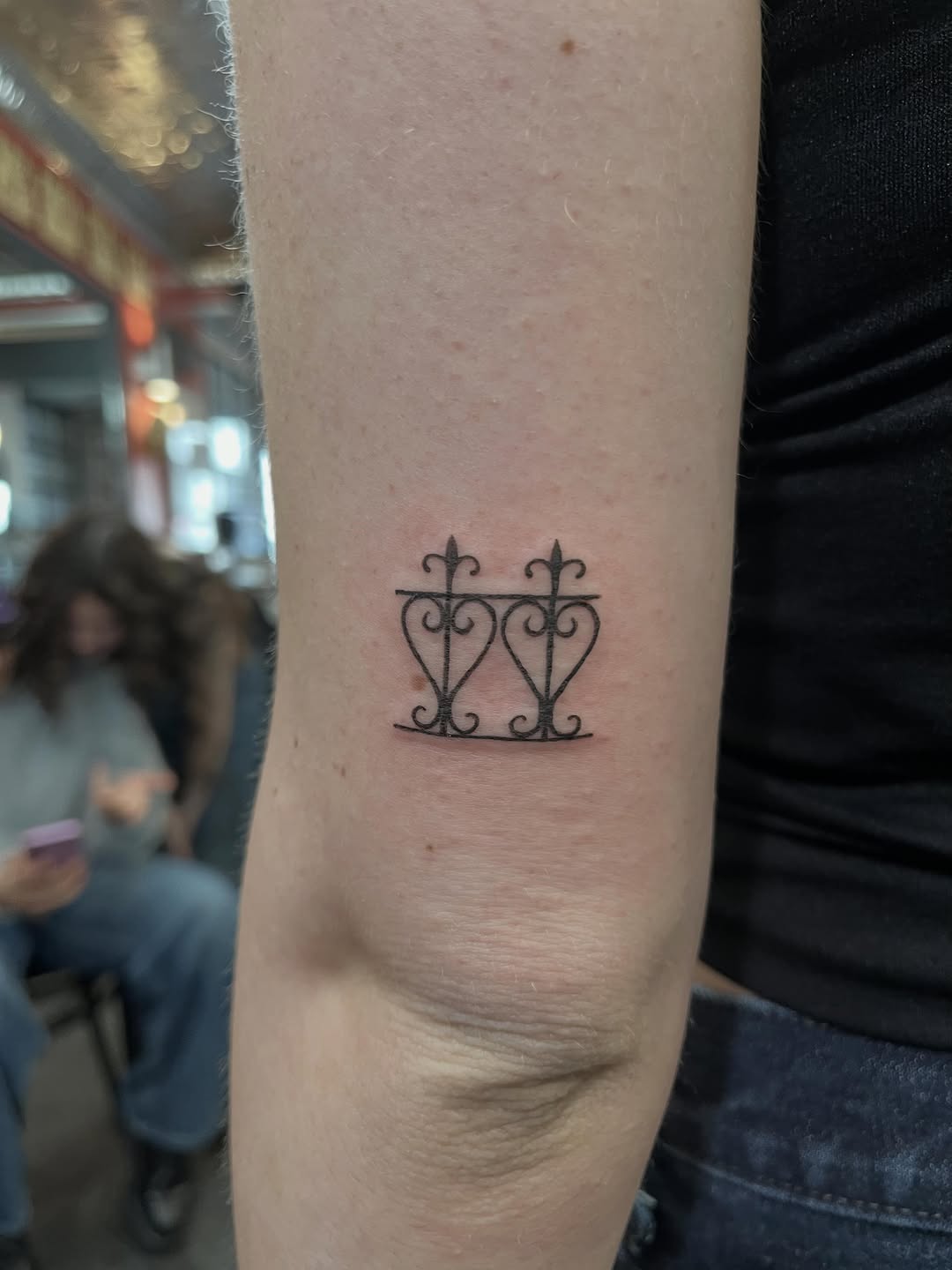 Ornamental fence with hearts fine line tattoo on the forearm by Jesus A.