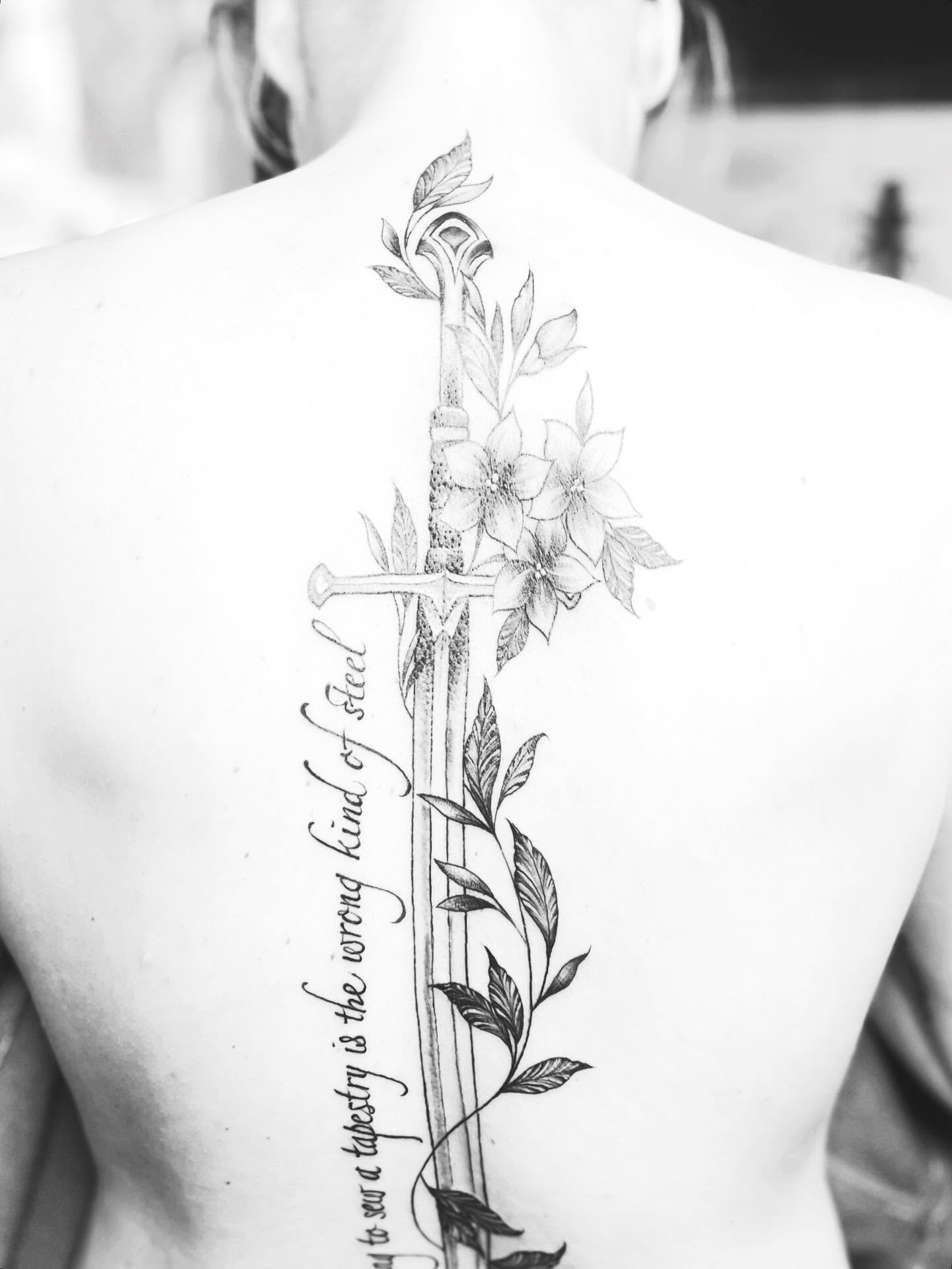 Sword and flowers realism tattoo on the back by Rikki