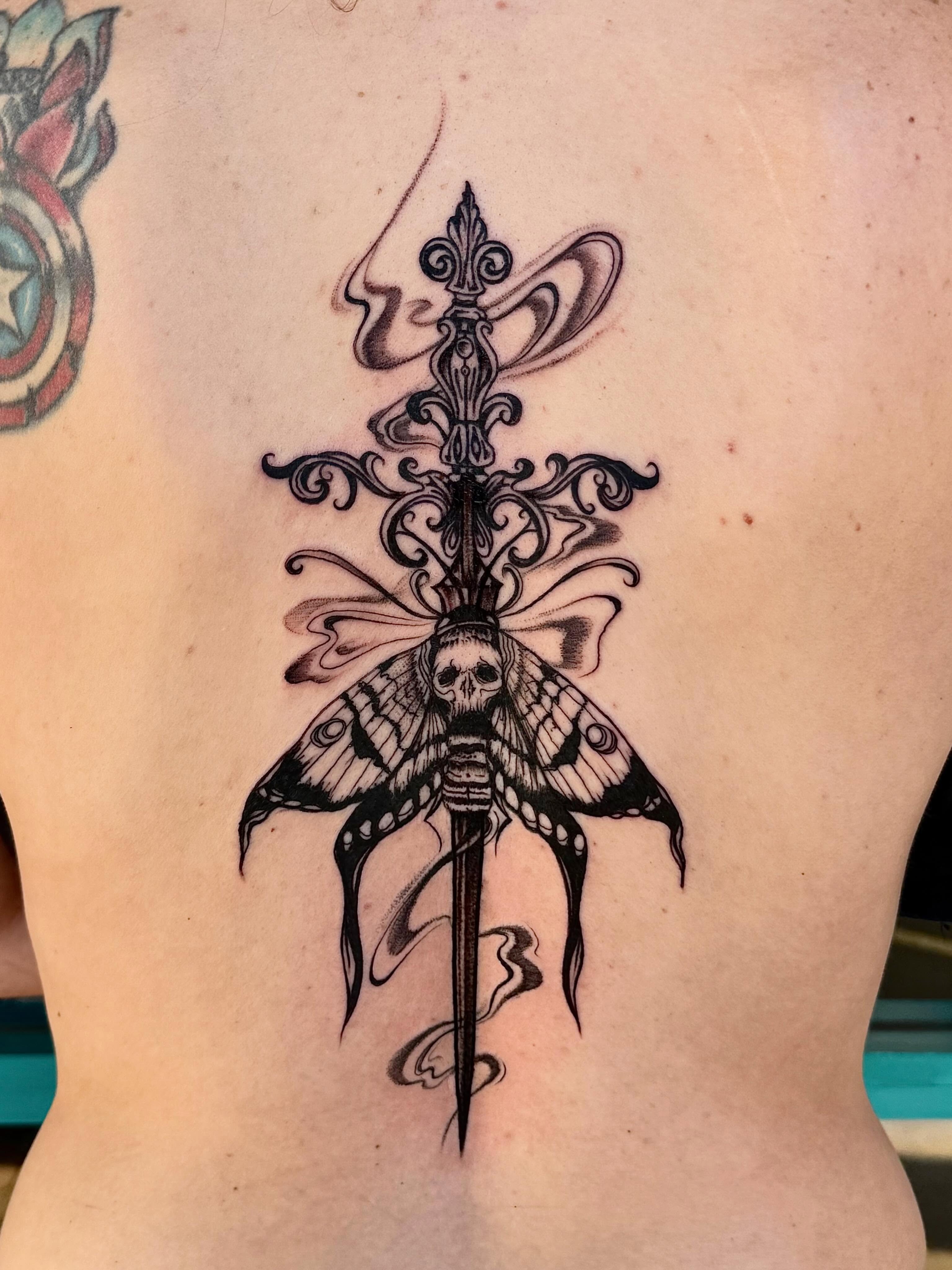 Moth and dagger ornamental tattoo on the back by McKenna Hughes