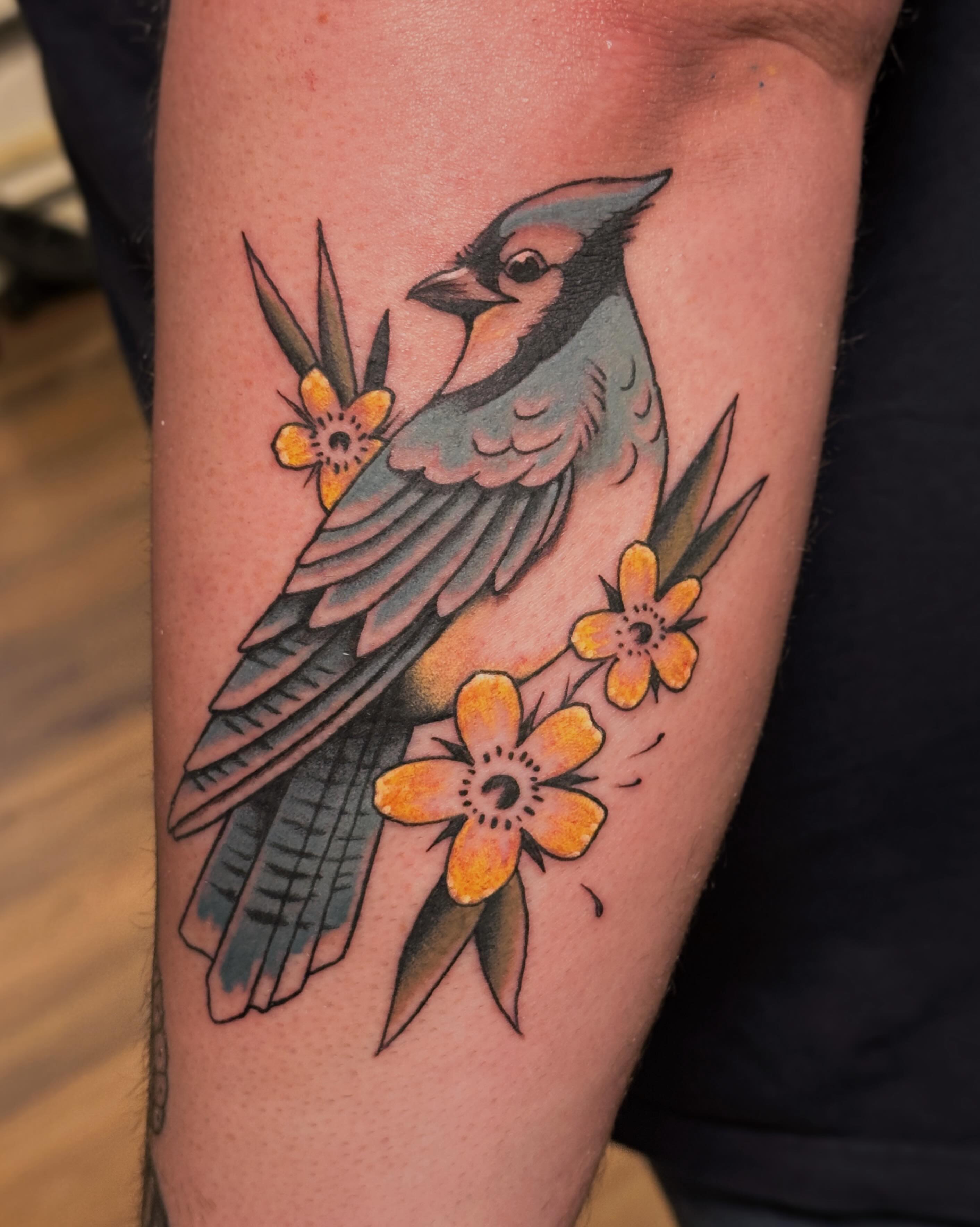 Bird and flowers American traditional tattoo on the forearm by Craig Ryans