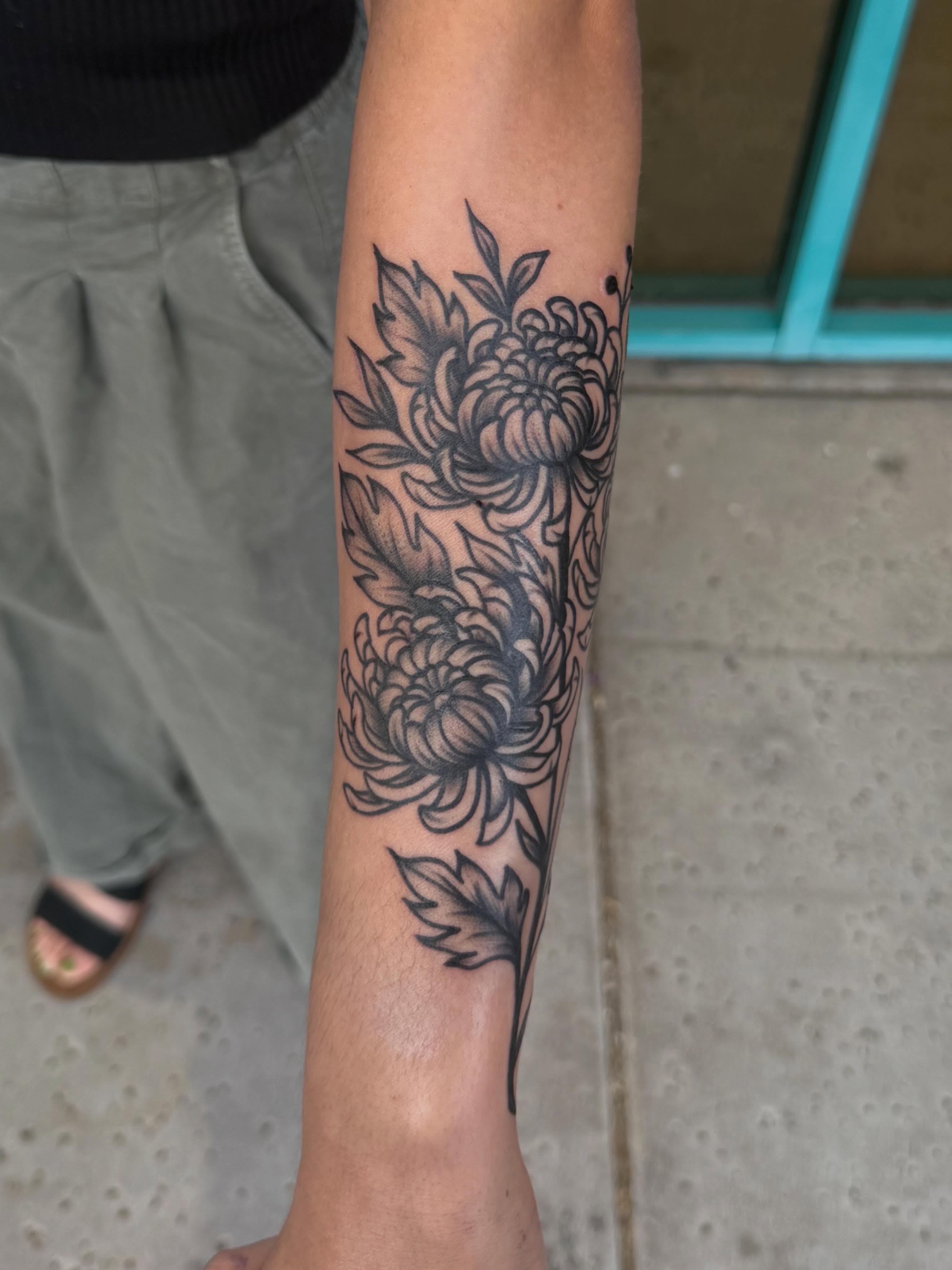 Chrysanthemums black and grey tattoo on the forearm by McKenna Hughes