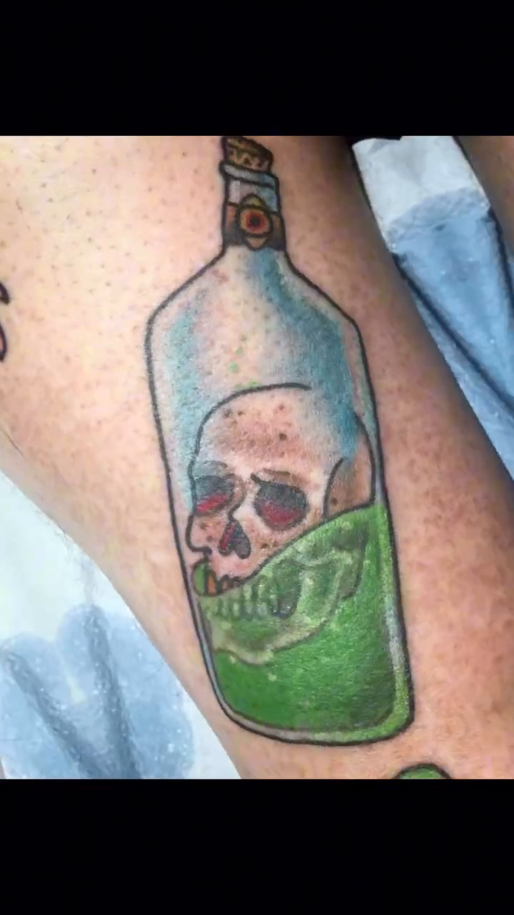 Bottle with skull and green liquid American traditional tattoo on the forearm by Davidsteeletattoos, Dallas, Texas