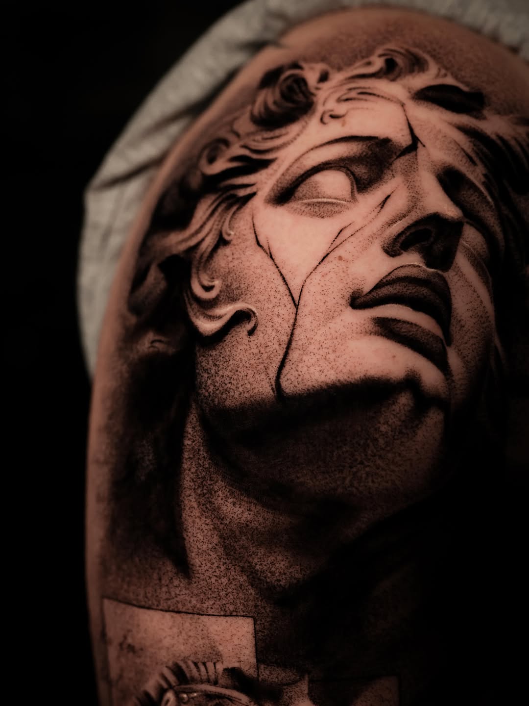 Broken statue face surrealism tattoo on the forearm by Nikita Grinenko, San Francisco