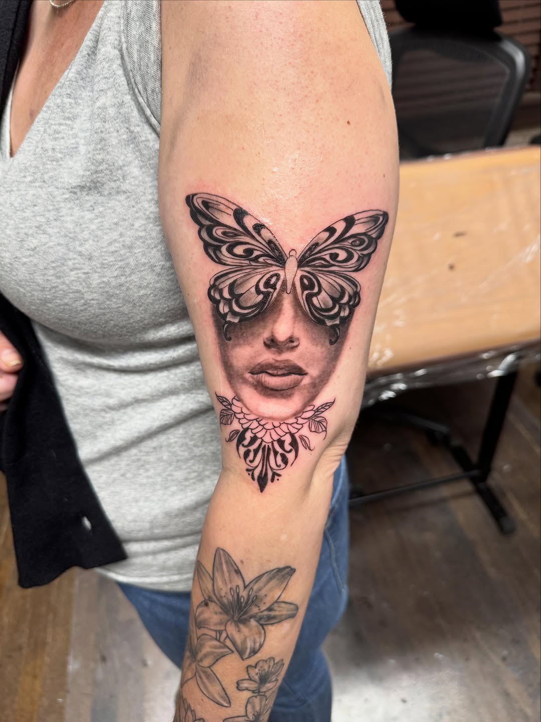 Woman's face with butterfly sketch tattoo on the forearm by Willi Tattoos👹
