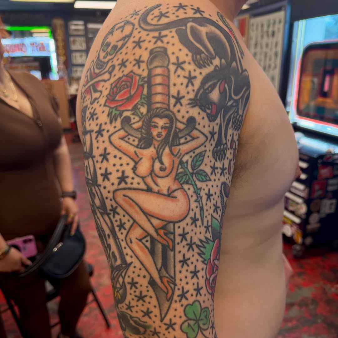 Naked woman with roses American traditional tattoo on the upper arm by Max mogstad