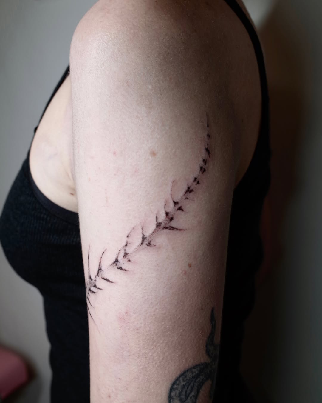 Spine black and grey tattoo on the upper arm by @havefun_tattoo
