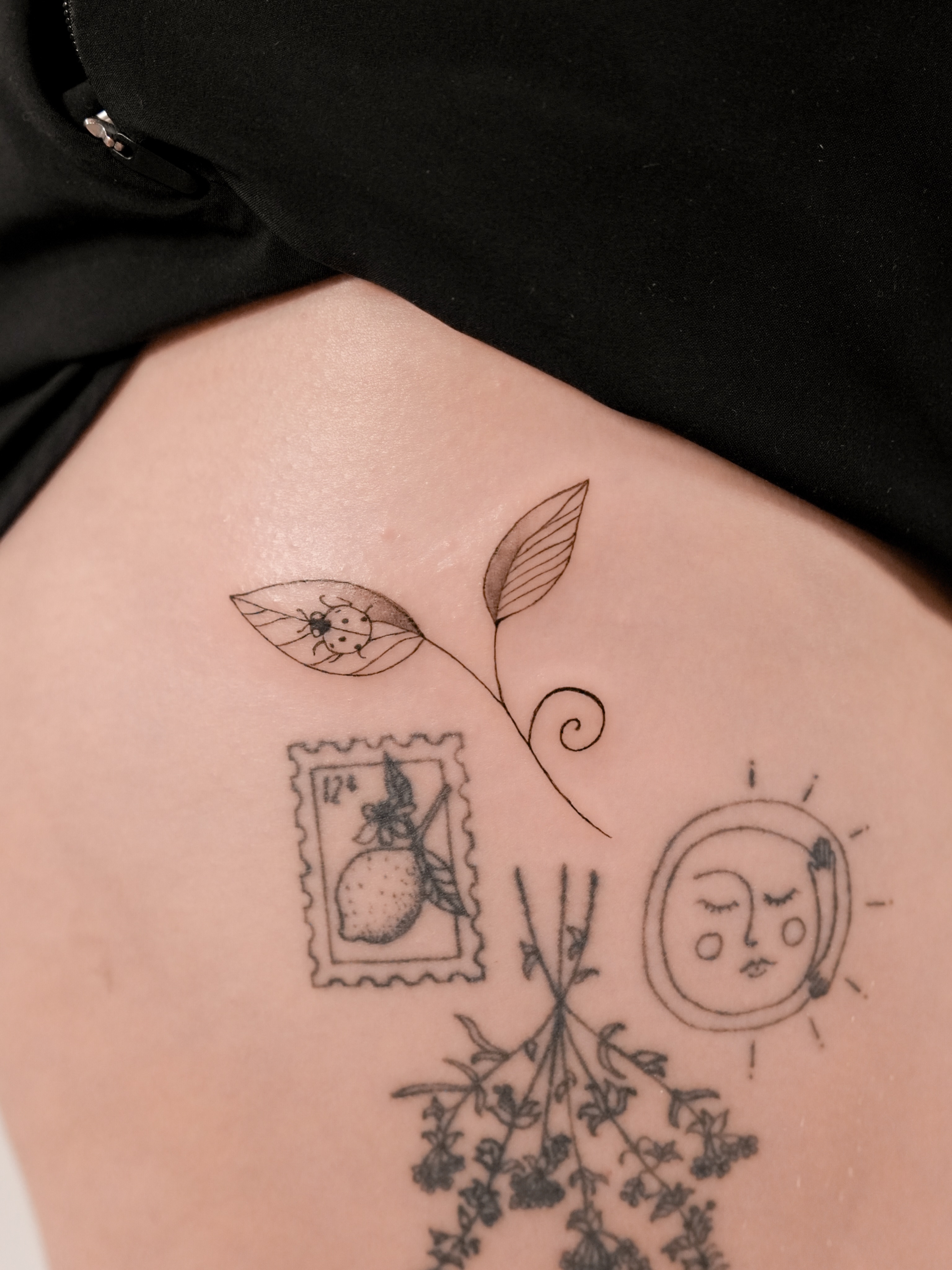 Botanical and celestial motifs black and grey tattoo on the torso by Ash - Fineline Tattoo Apprentice
