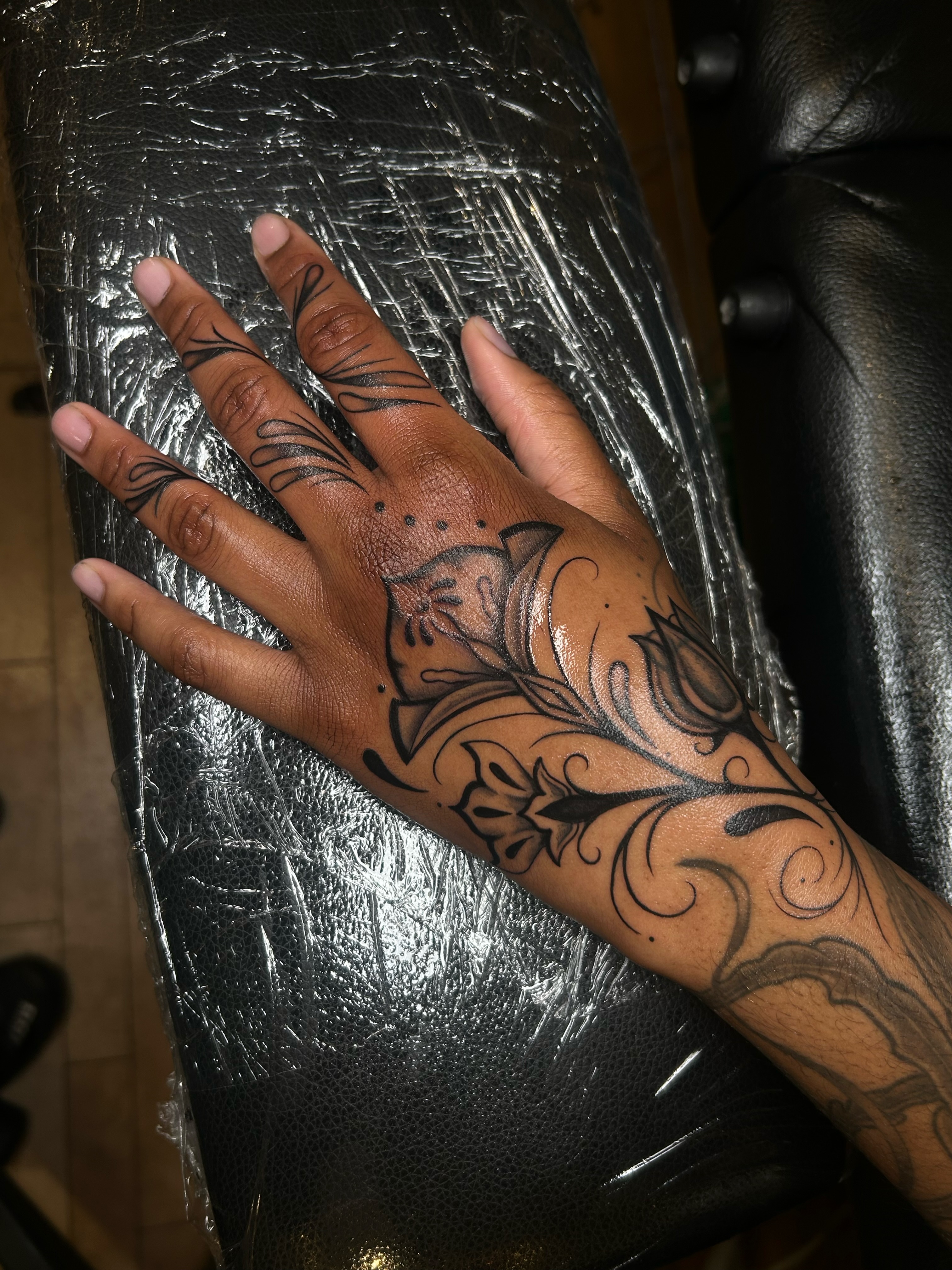 Floral design black and grey tattoo on the hand by ༻𝐓𝐡𝐞 𝐒𝐤𝐢𝐧 𝐆𝐚𝐫𝐝𝐞𝐧༺
