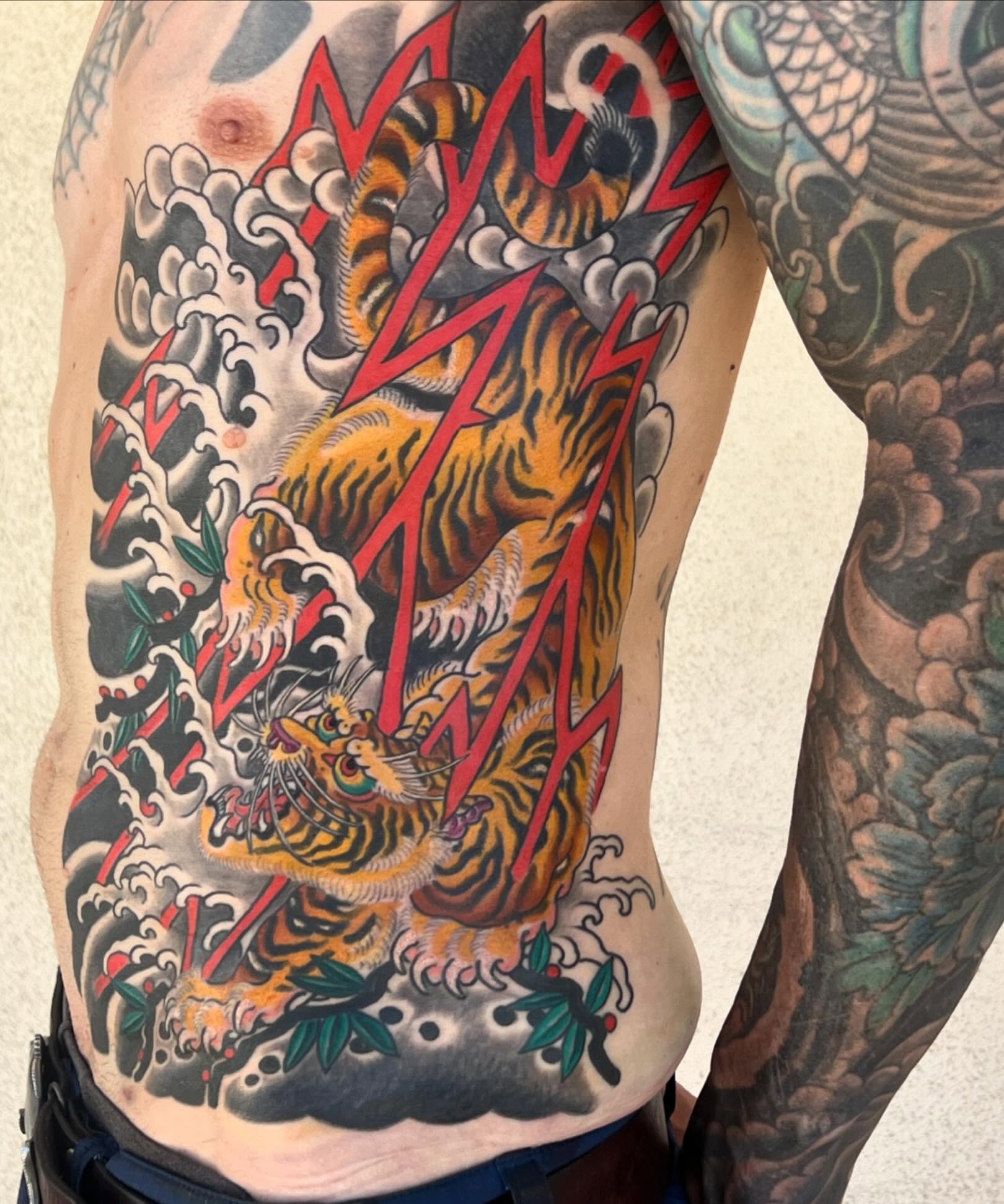 Tiger and lightning japanese irezumi tattoo on the ribs by Kayle Leogrande