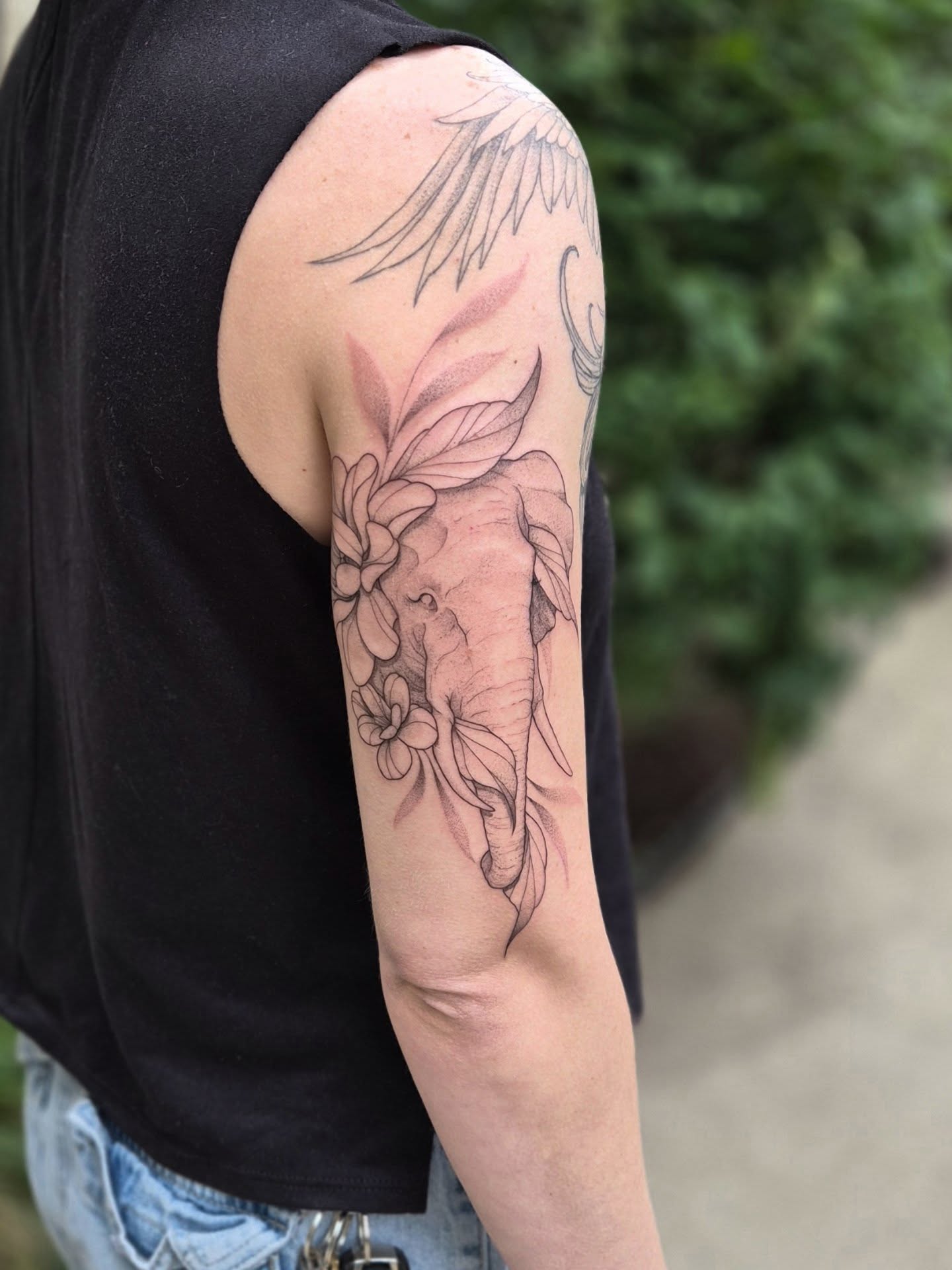 Elephant with flowers black and grey tattoo on the upper arm by Sophorn Long (soapy)