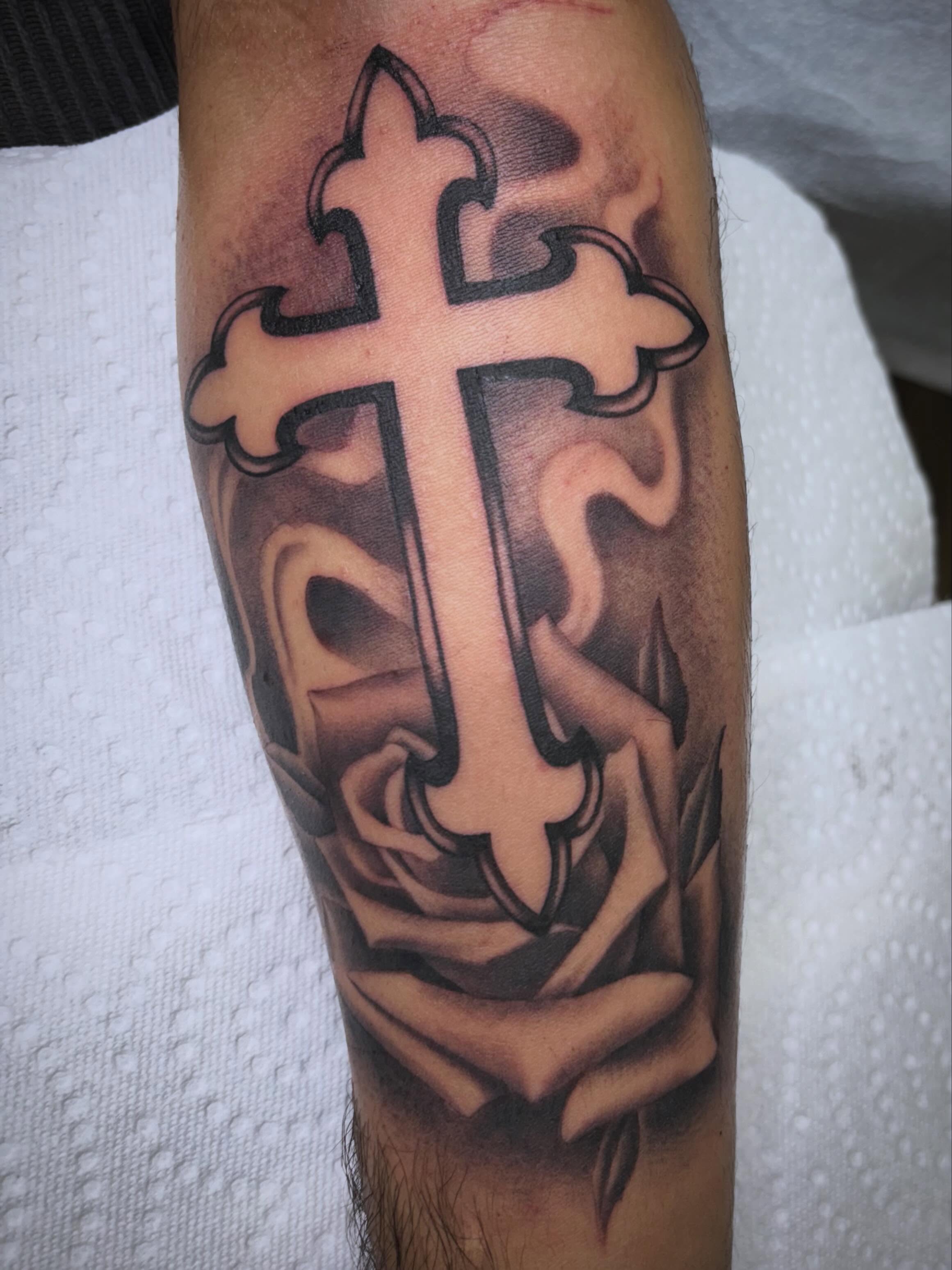 Cross and rose realism tattoo on the forearm by Jay