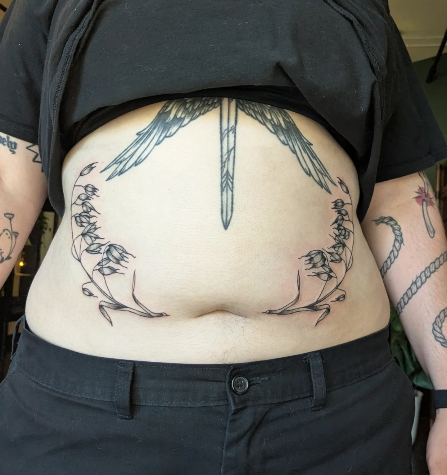 Bird and floral wreath black and grey tattoo on the torso by Madison Cañedo ✺ Portland tattoo