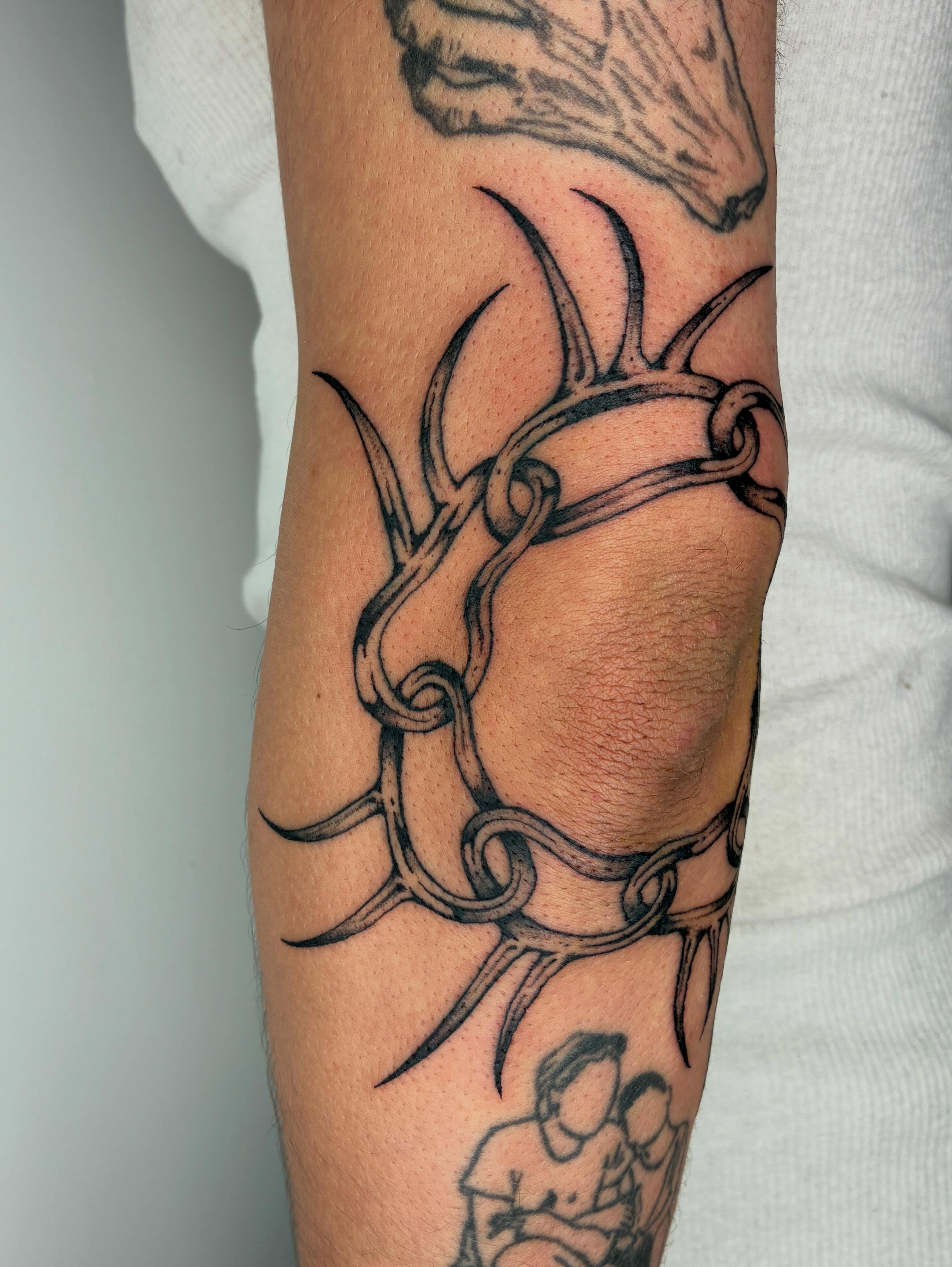 Antlers and chain tribal tattoo on the forearm by Steven Sessler, San Francisco, California