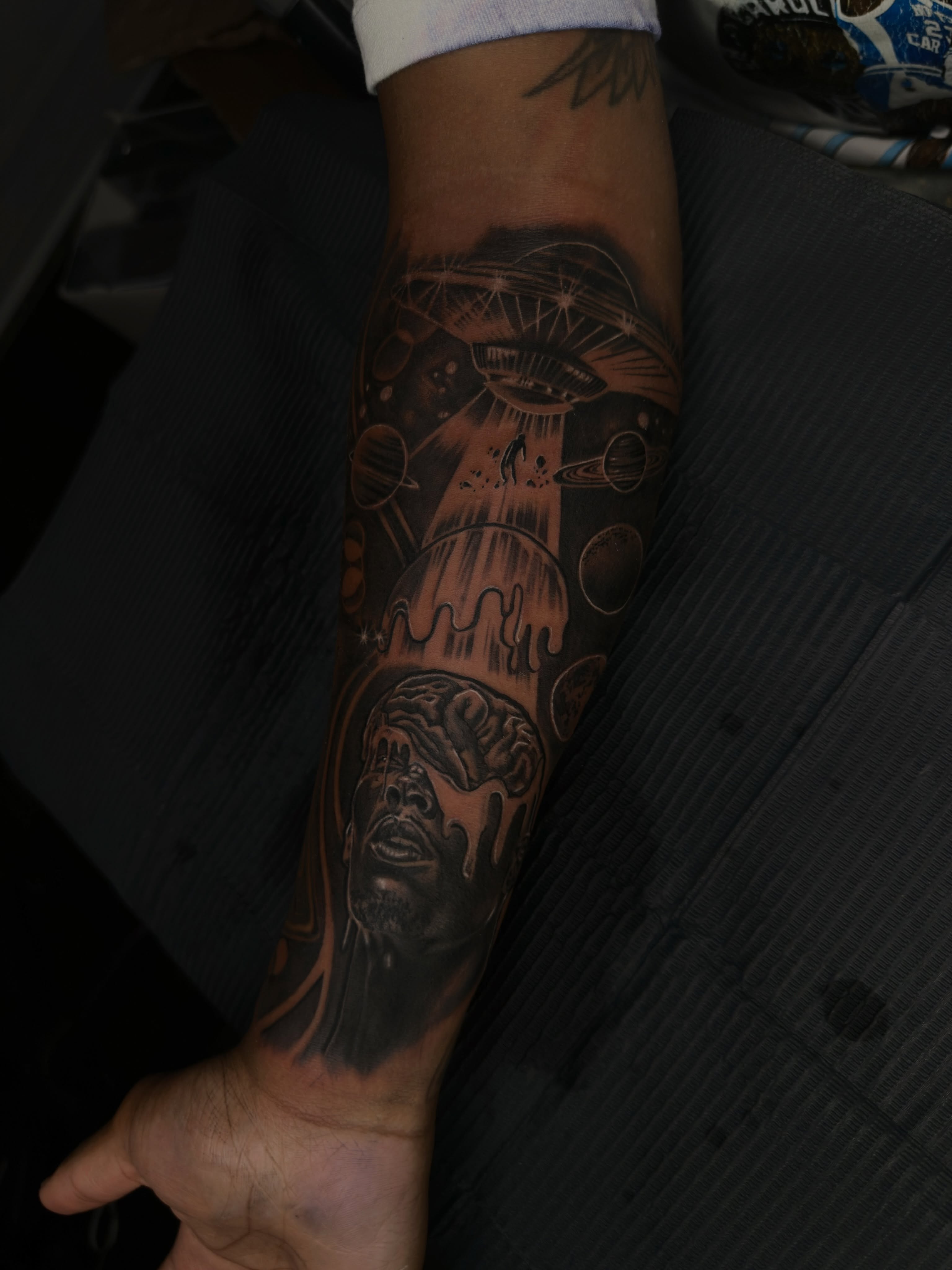 Astronaut and space realism tattoo on the forearm by Mando
