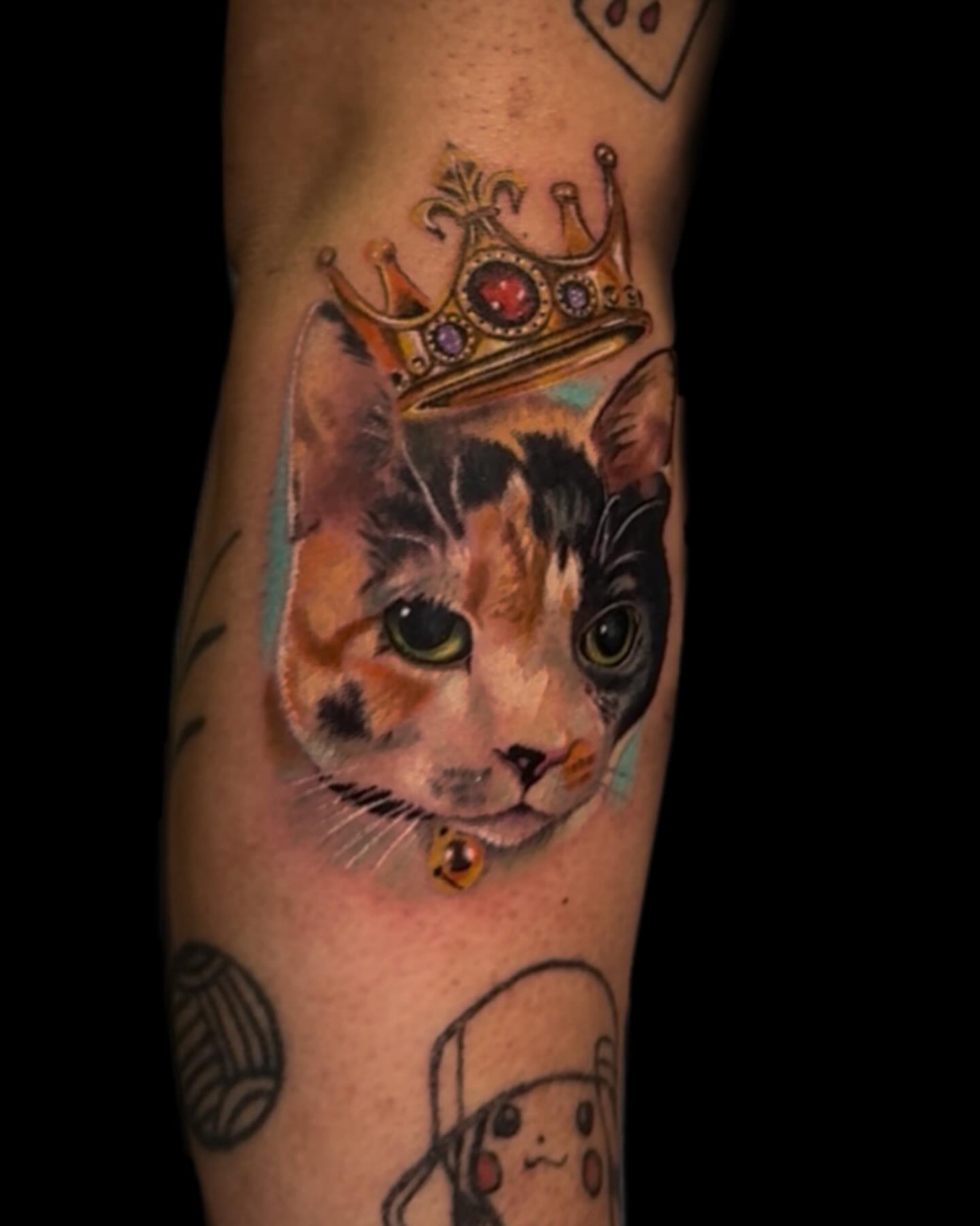 Cat wearing crown realism tattoo on the forearm by Amanda Lineweaver