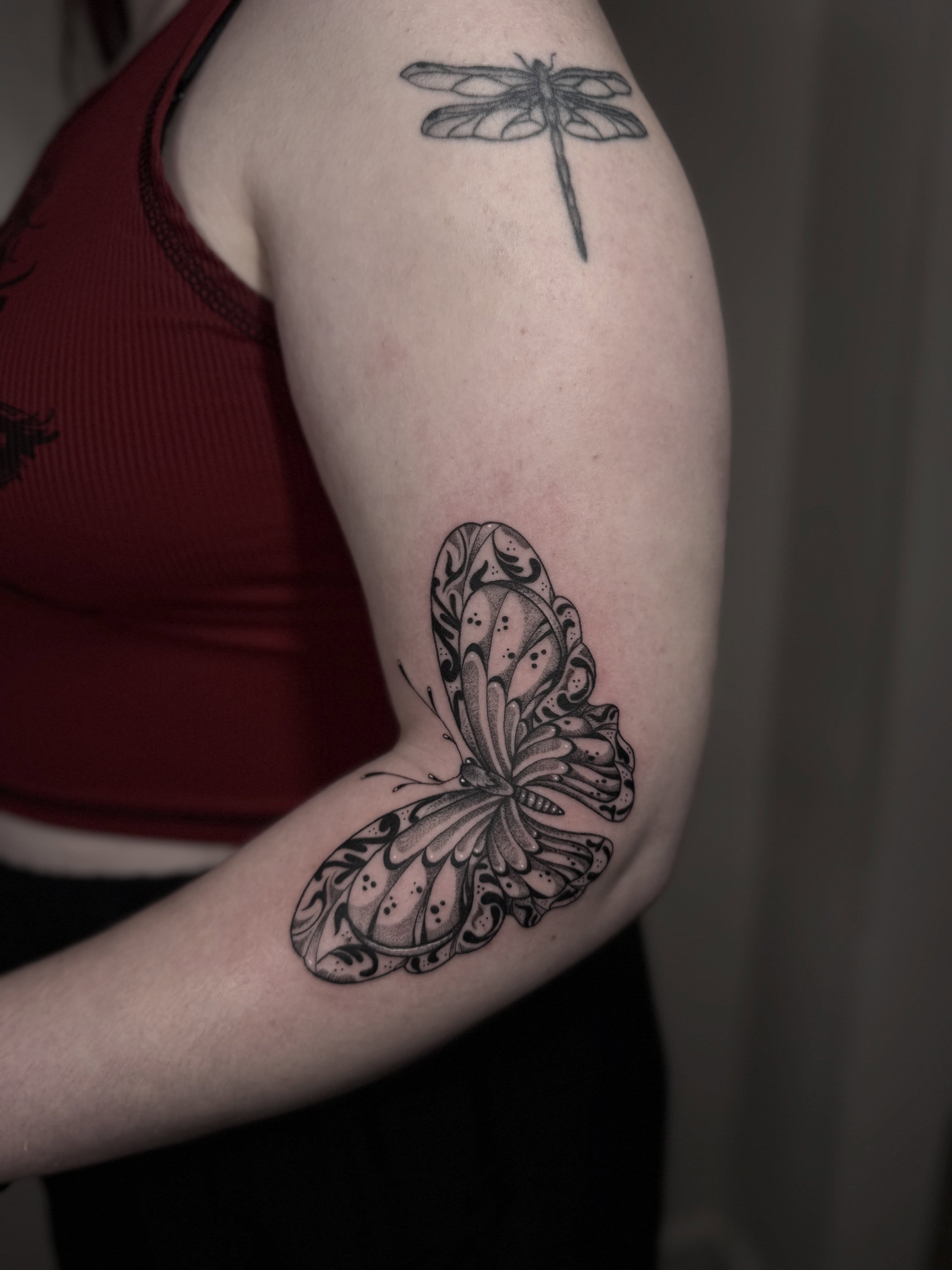 Butterfly black and grey tattoo on the upper arm by Mara Flores βπΛβ§