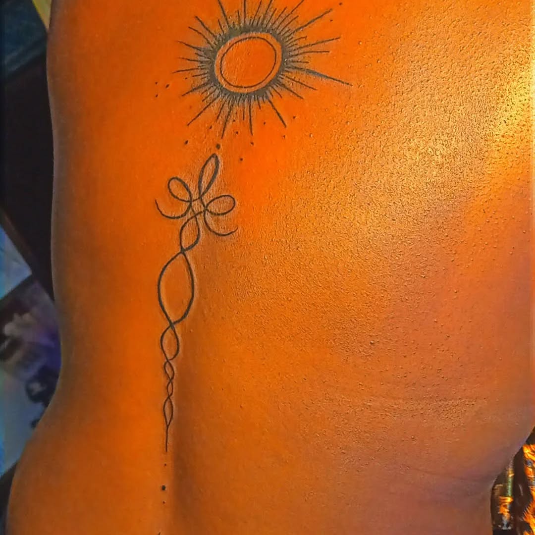 Sun and abstract symbol ornamental tattoo on the back by Mwangaza Bodyworks, Uthiru, Nairobi Area, Kenya