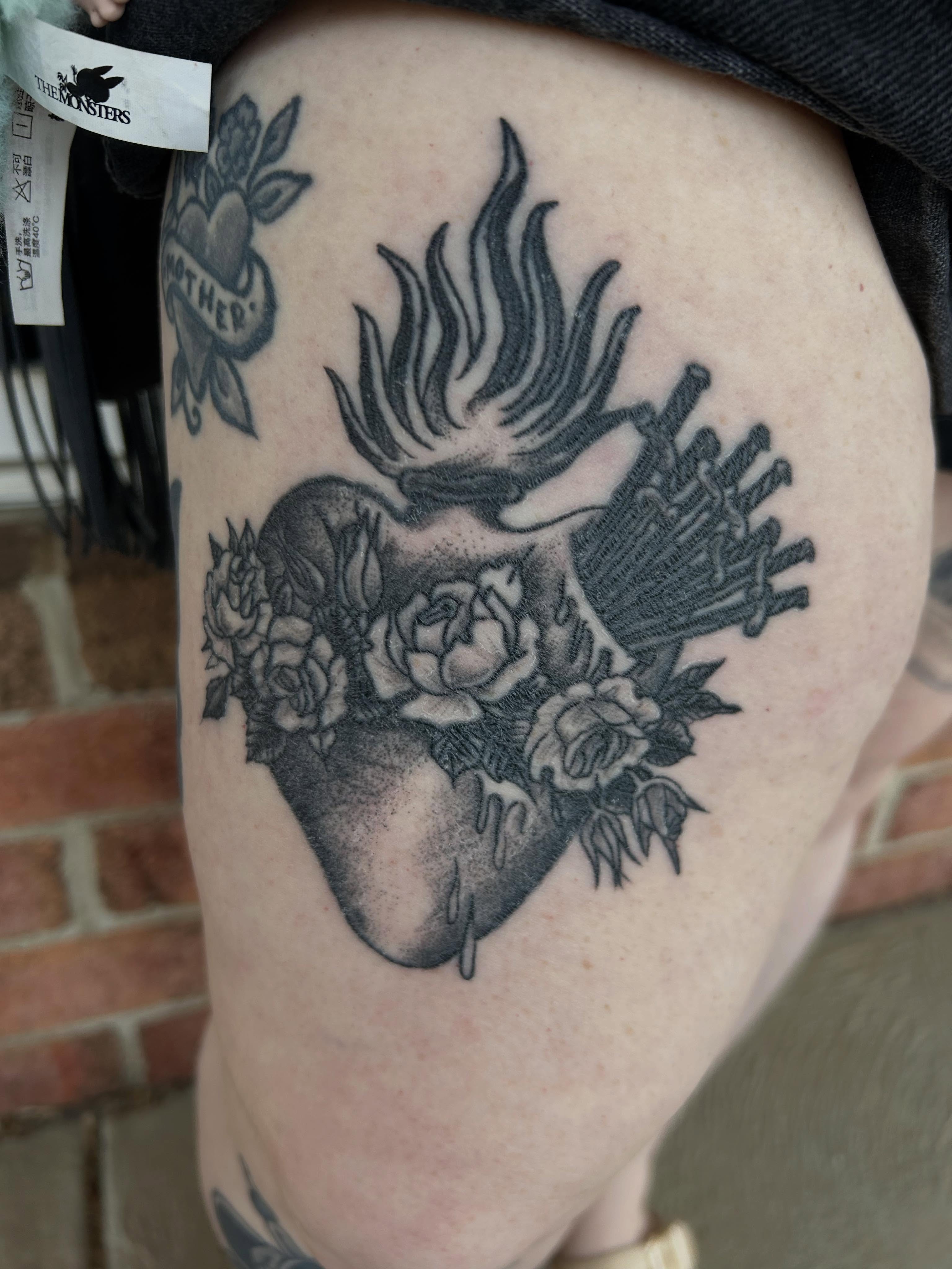 Heart with flames and roses dotwork tattoo on the thigh by Stogie Tony