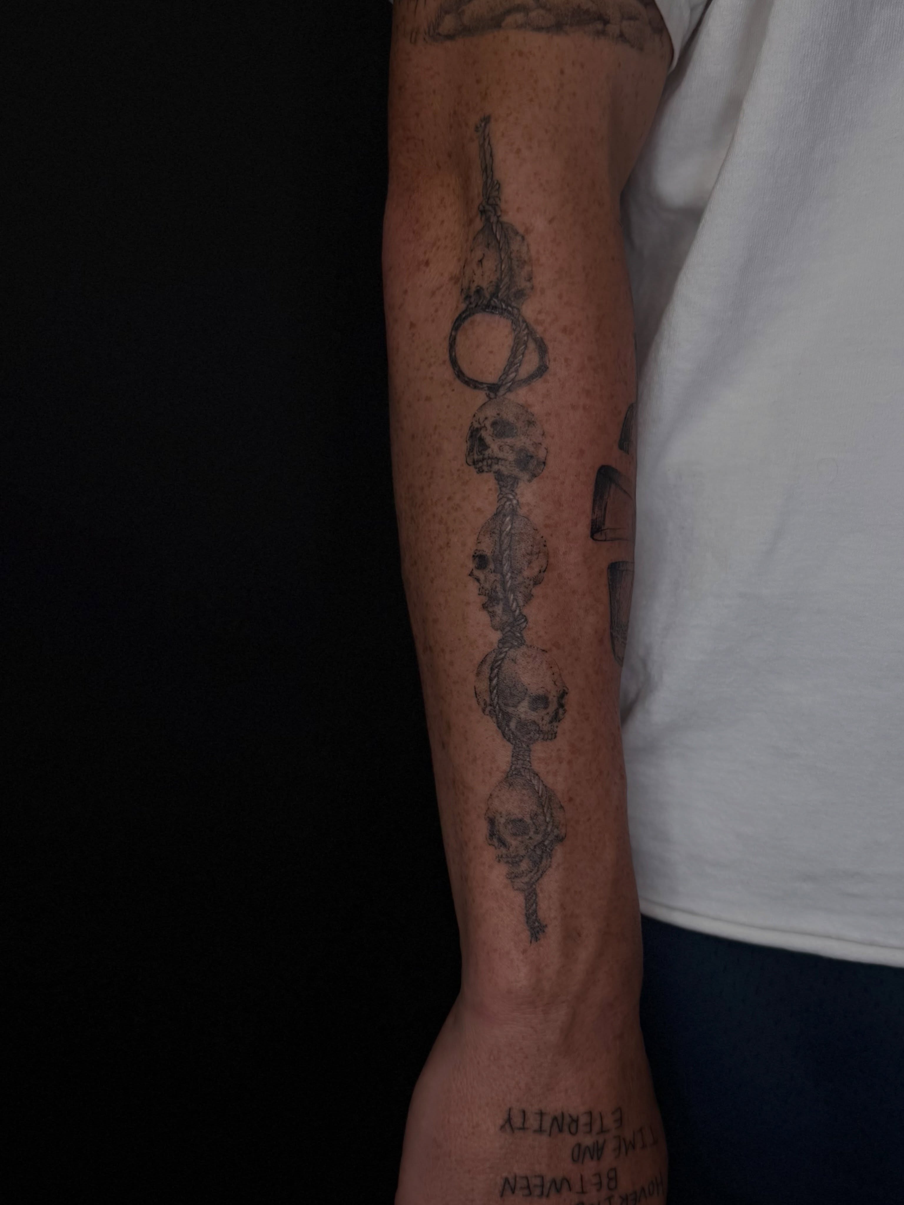 Skulls and chain black and grey tattoo on the forearm by B o n d B o n d , “ a r t i s t “