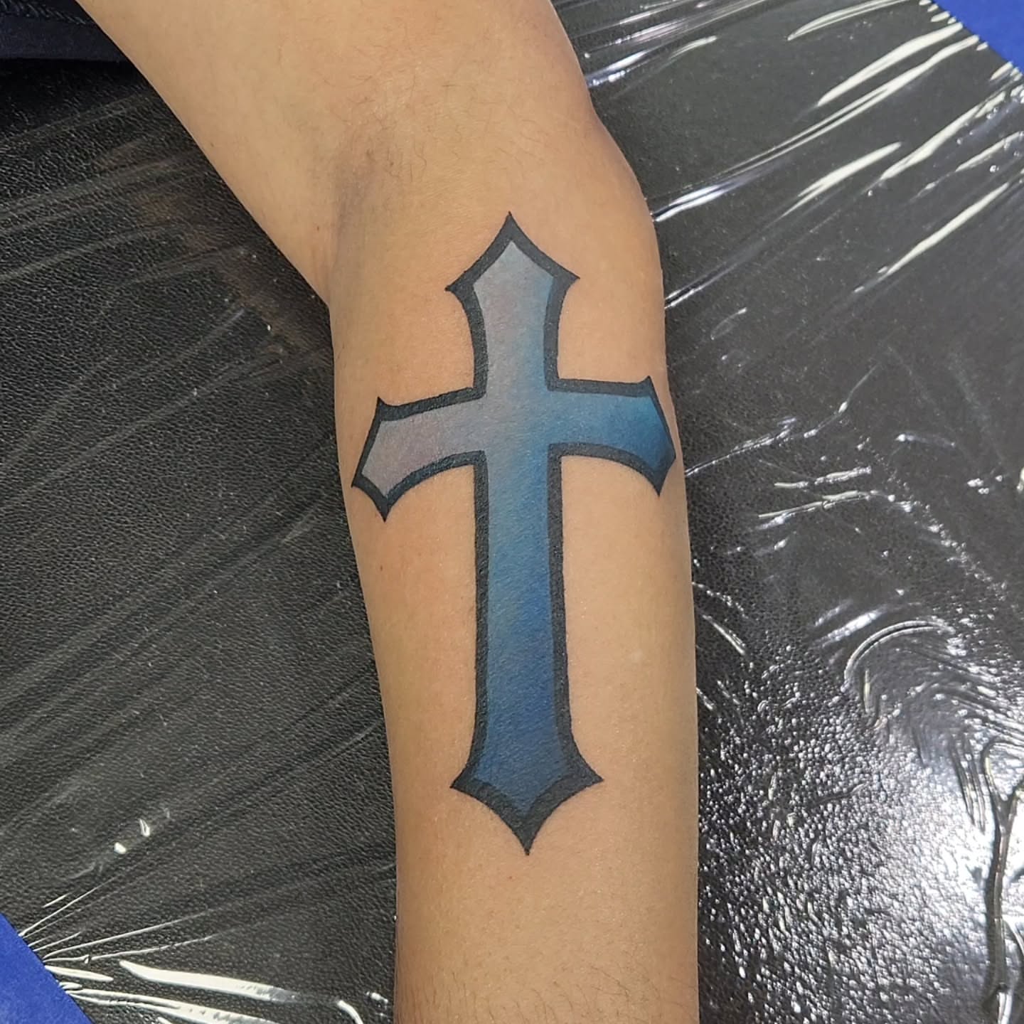 Cross black and grey tattoo on the forearm by Jason August