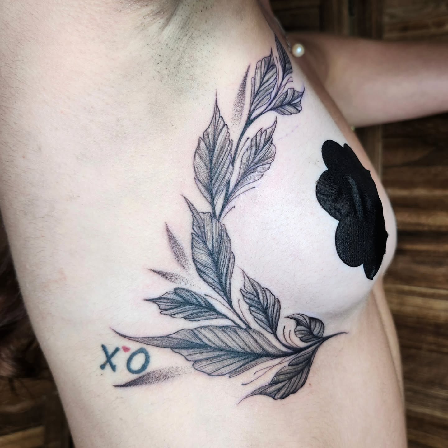 Feather wreath dotwork tattoo on the chest by Kelly Zito