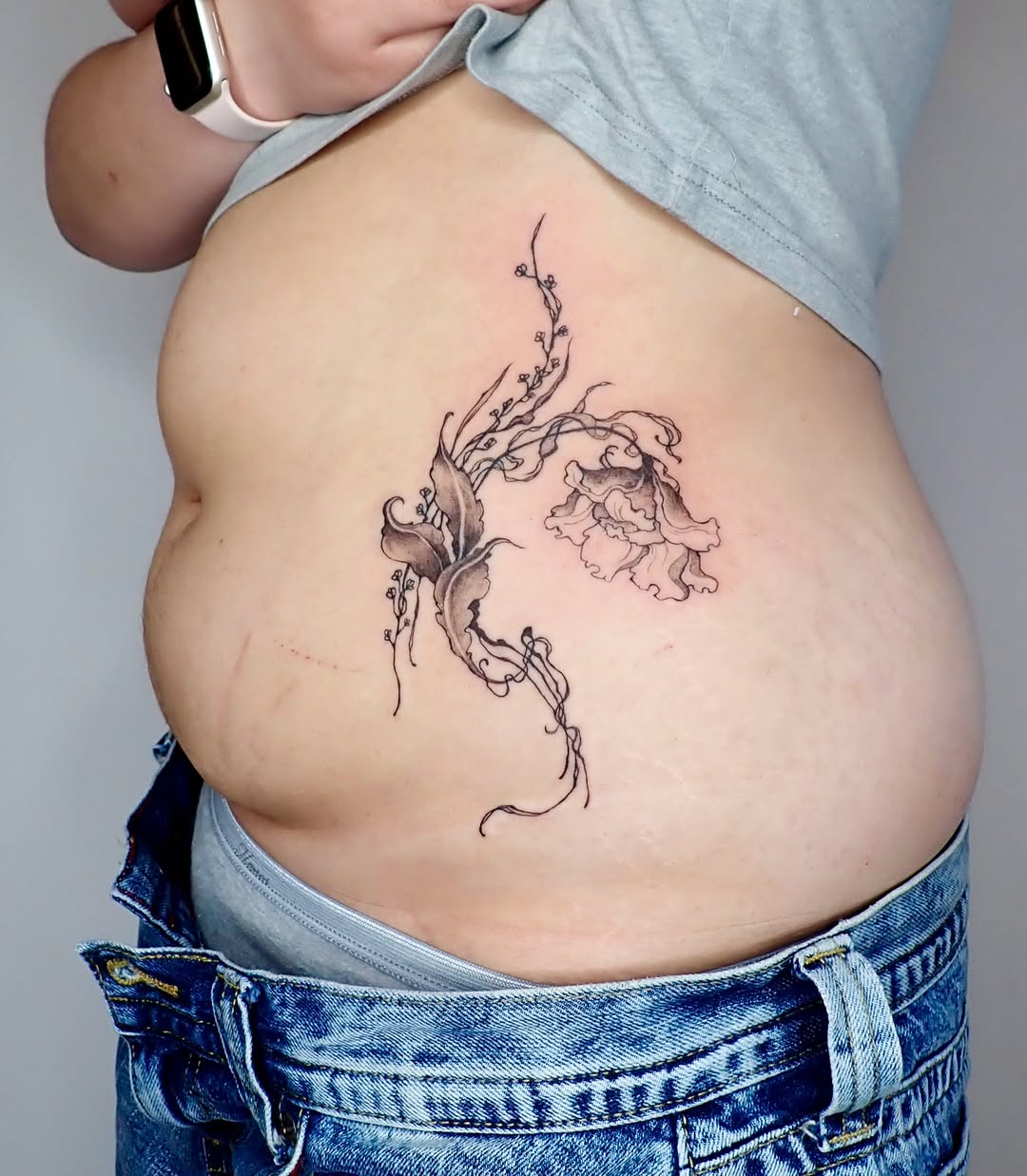Flower and vines blackwork tattoo on the torso by thalia