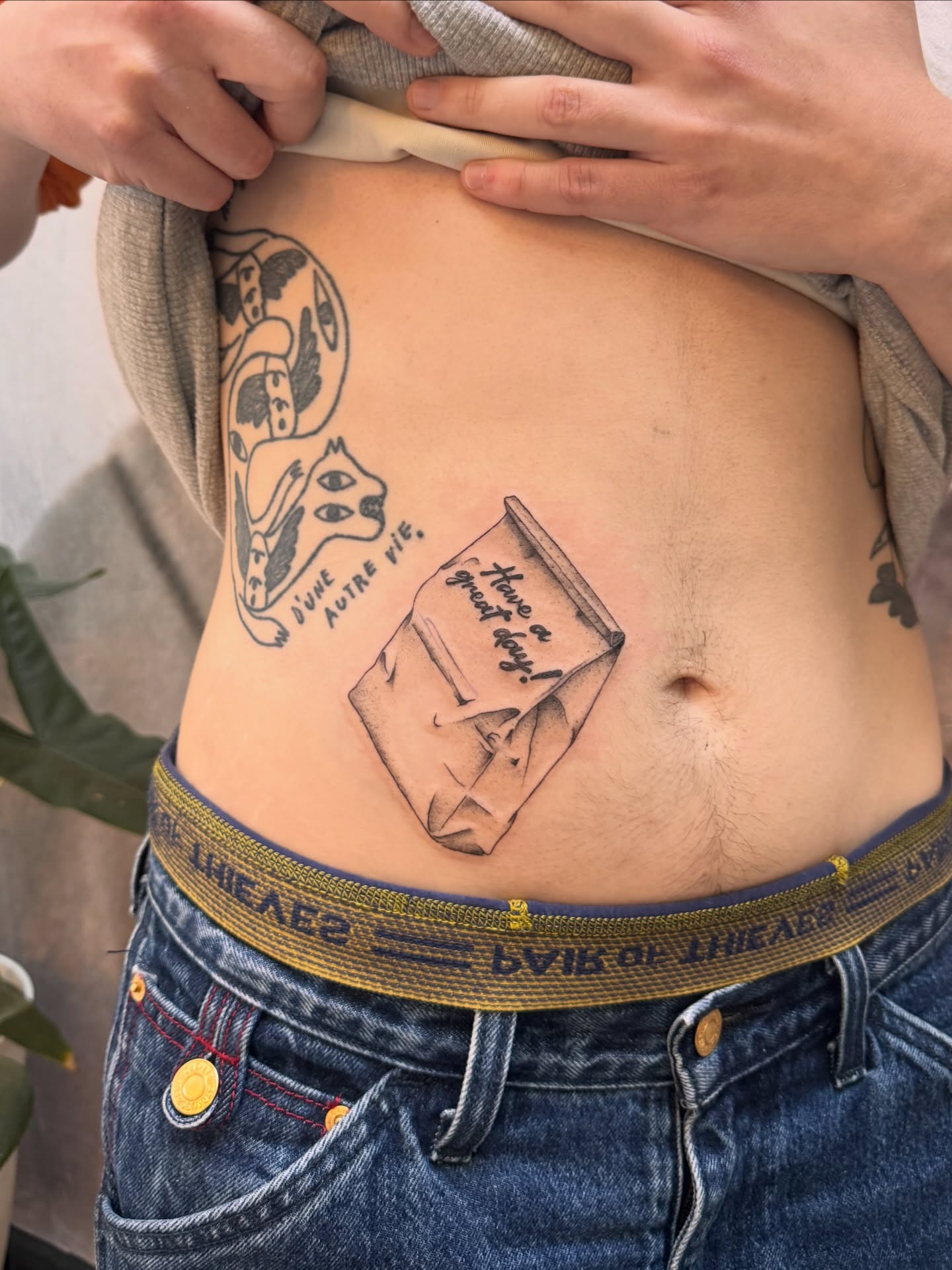 Book and envelope black and grey tattoo on the torso by Sam Padilla