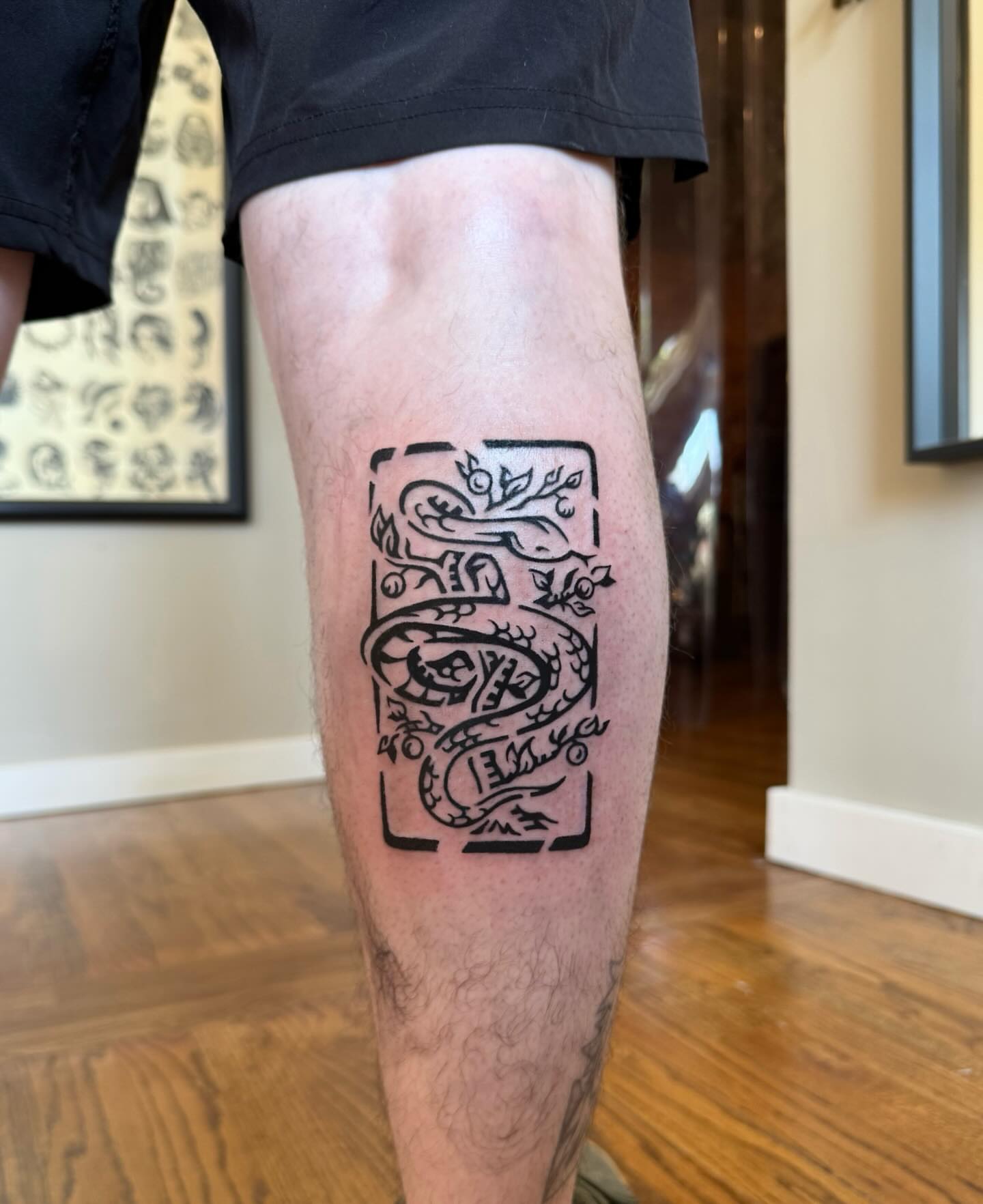 Snake and leaves black and grey tattoo on the thigh by M
