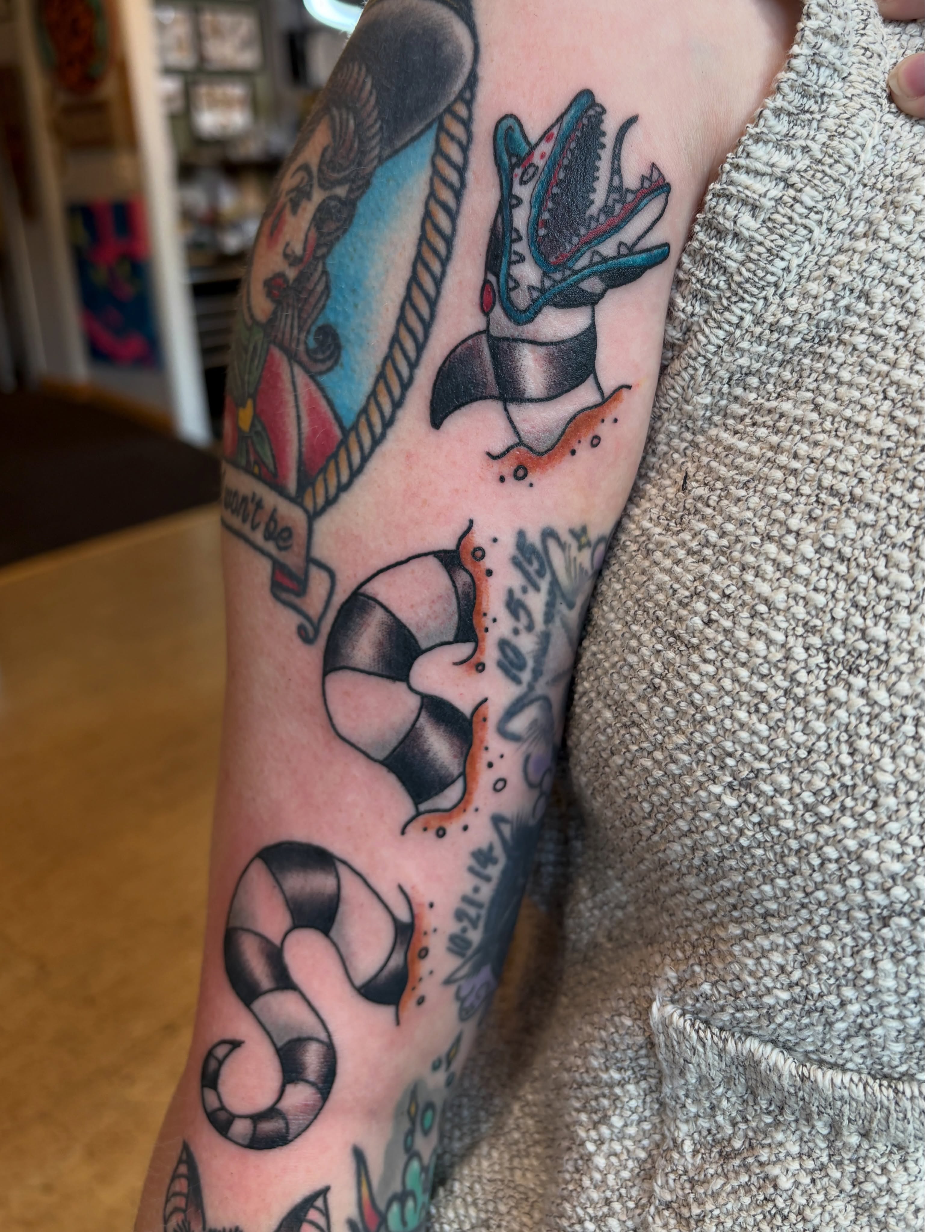 Dinosaur and life preserver American traditional tattoo on the forearm by Kimber Teatro, Portland, Oregon