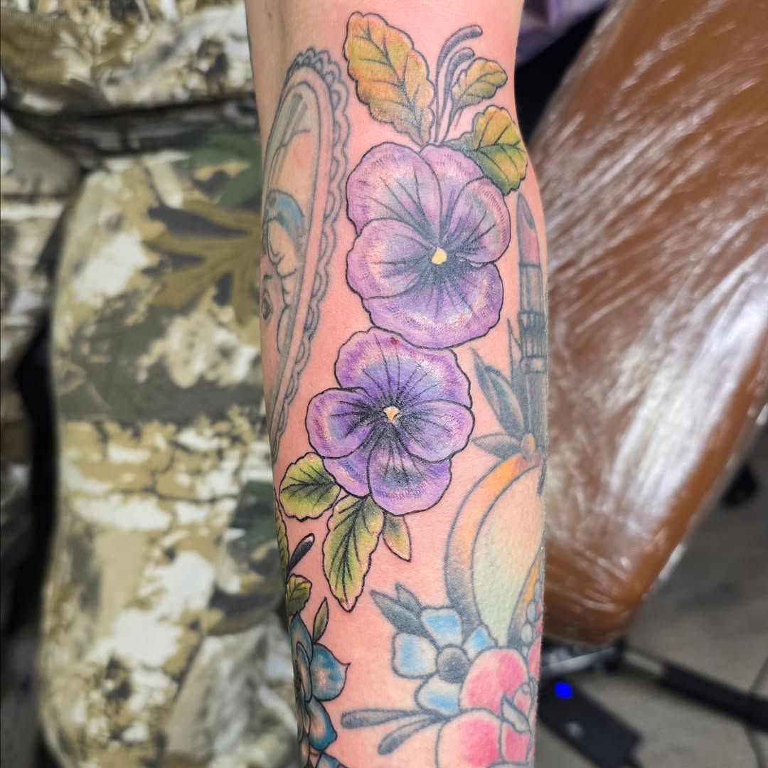 Purple pansies watercolor tattoo on the forearm by Val Sanchez