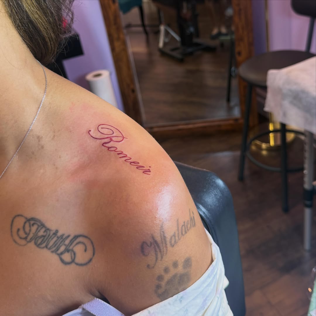 Names and footprint lettering script tattoo on the shoulder by Jay