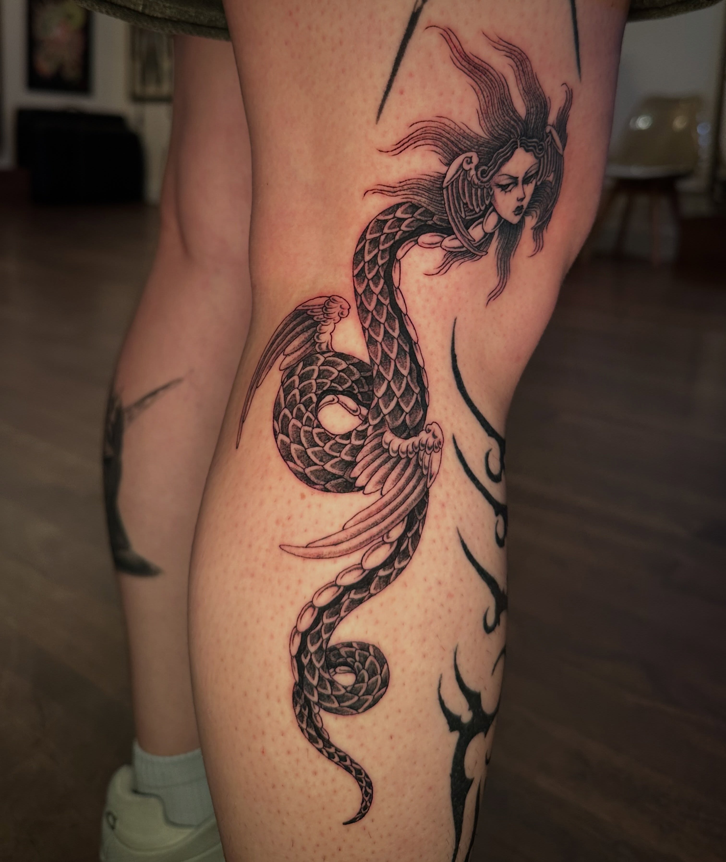 Mermaid and snake dotwork tattoo on the thigh by Bree Lin