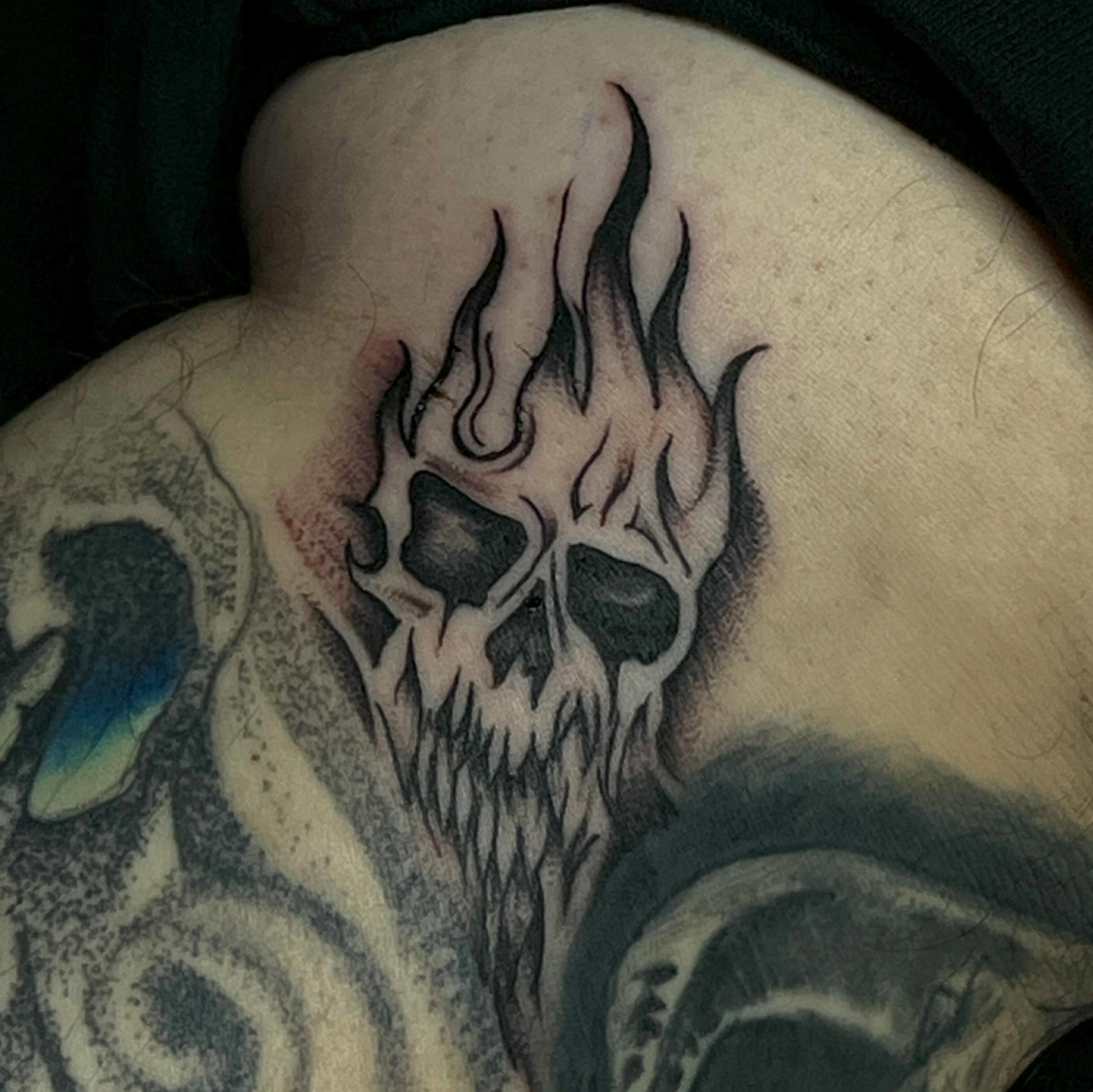 Flaming skull black and grey tattoo on the shoulder by Tattoomobile