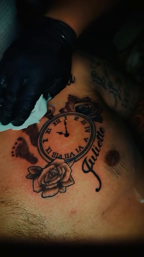 Clock with names and roses realism tattoo on the chest by MY$T