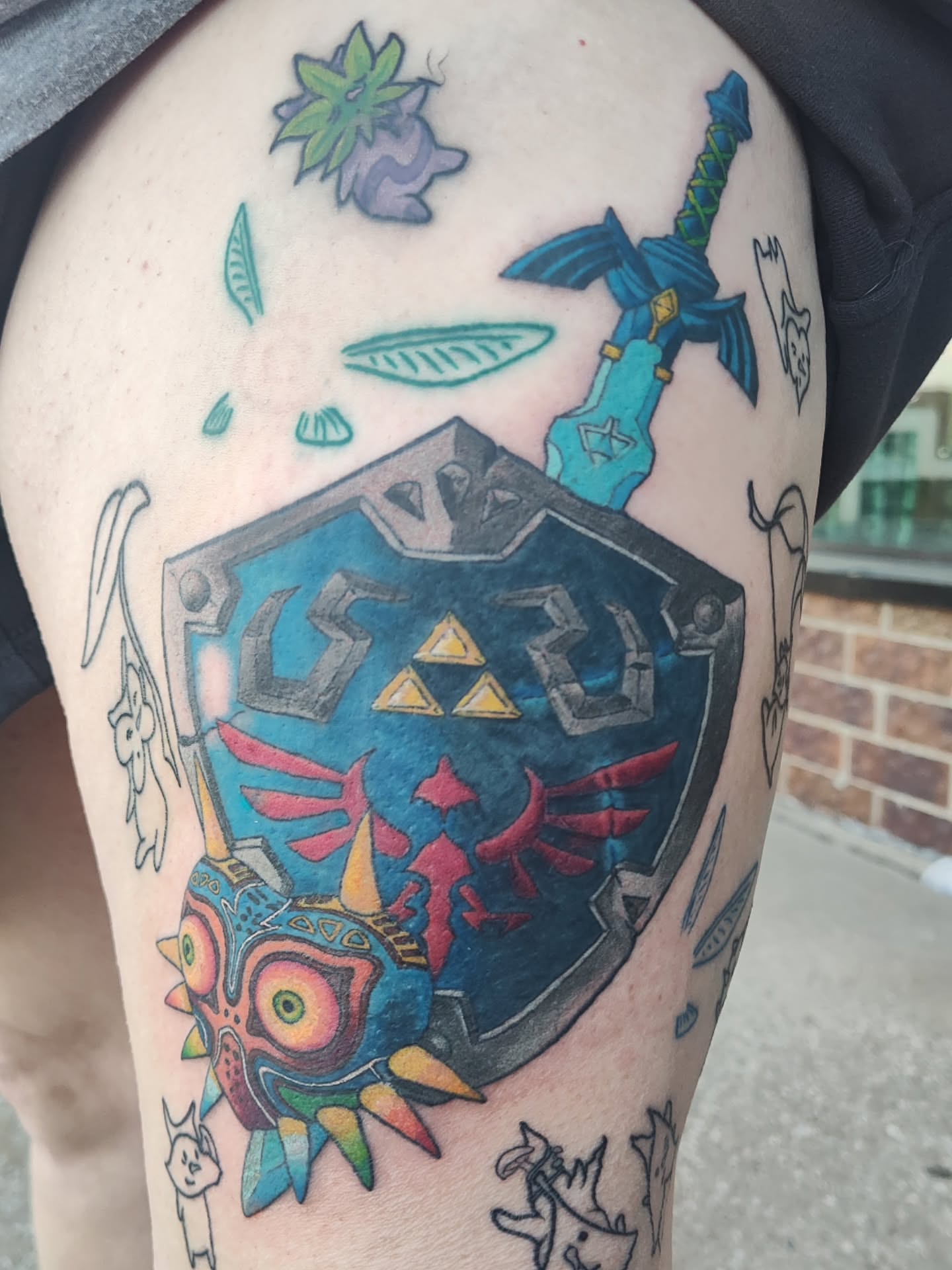 Zelda triforce shield new school tattoo on the thigh by Mercury