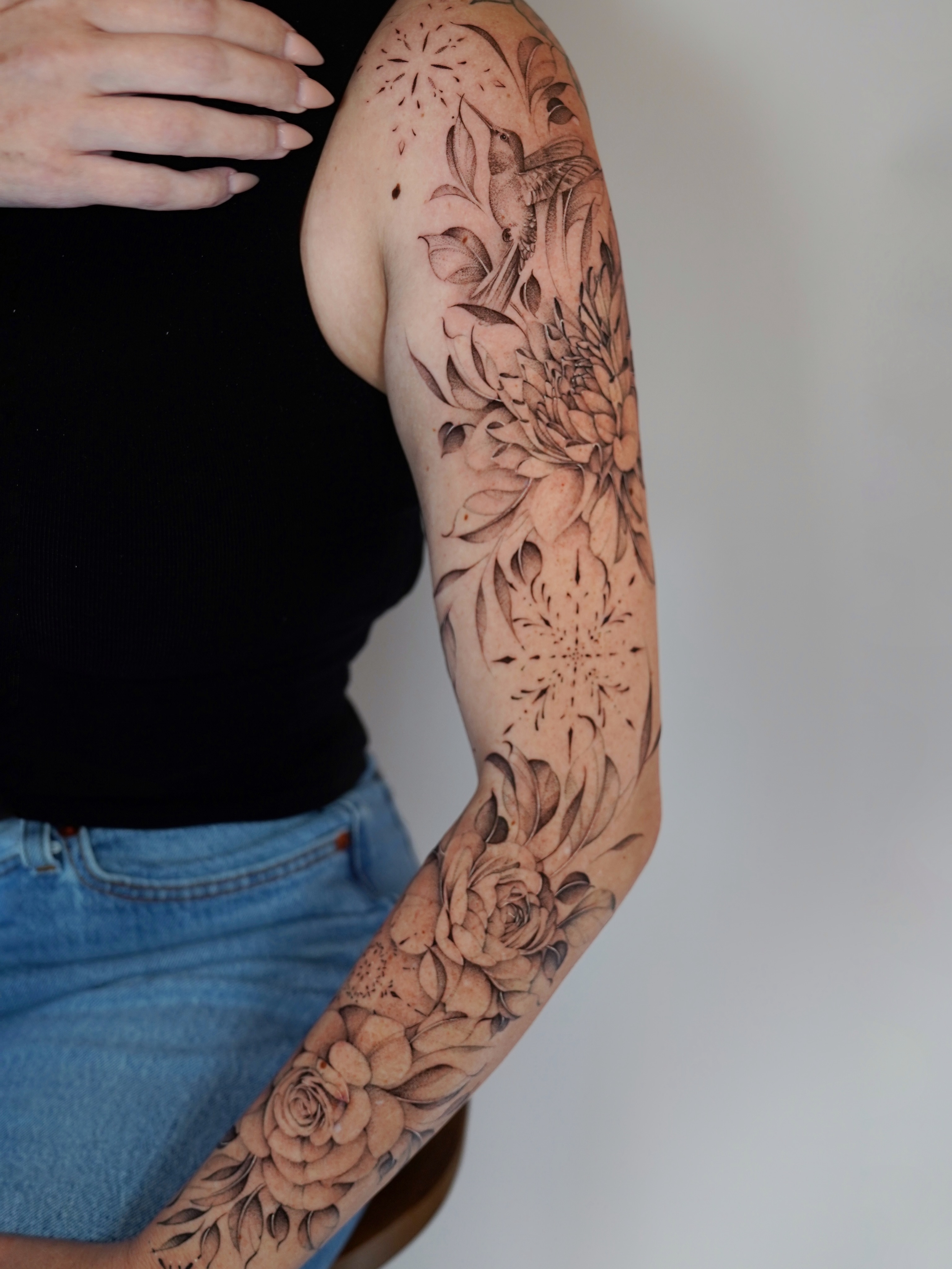 Floral bouquet black and grey tattoo on the upper arm by Bel Fernandez