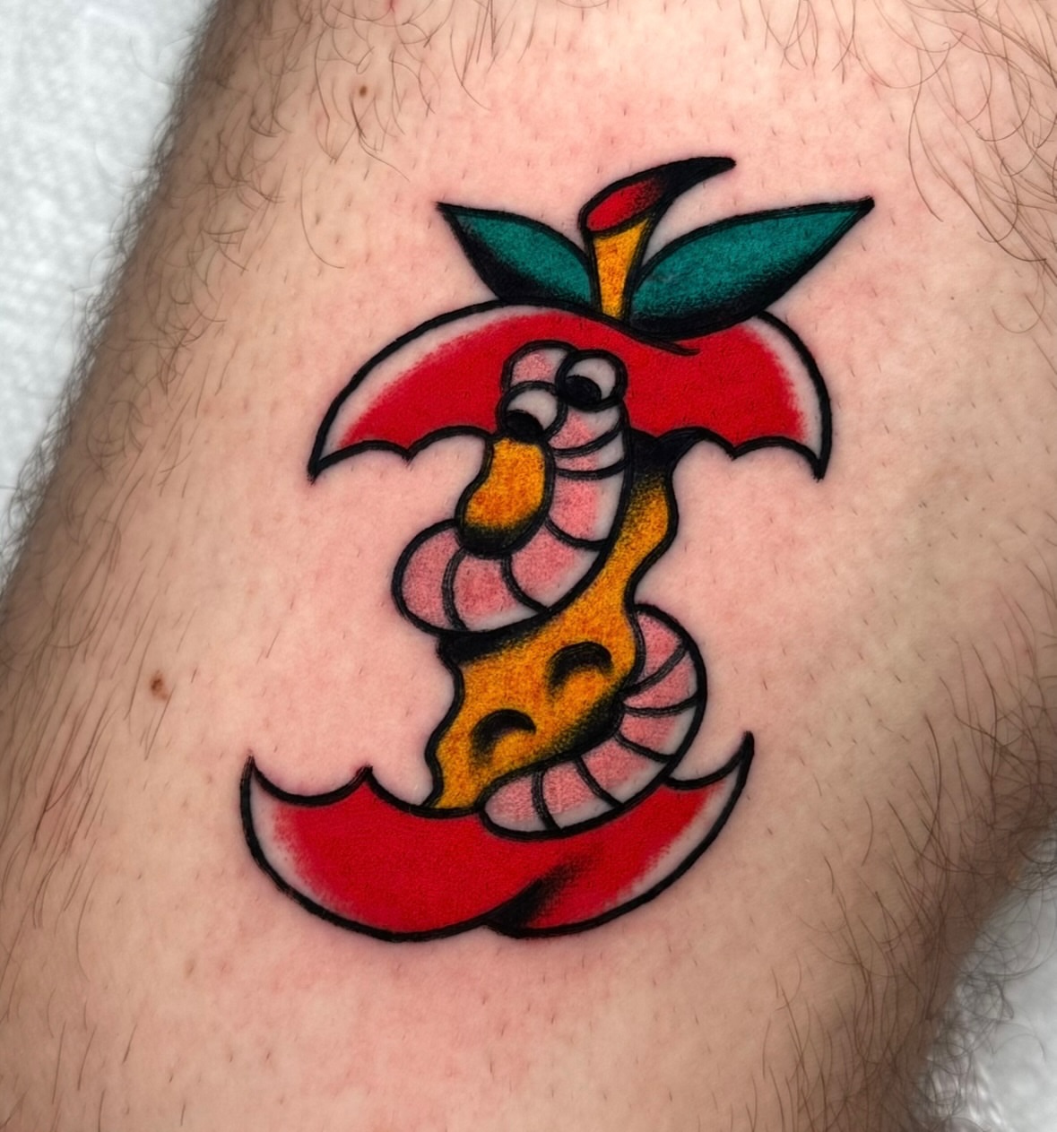 Apple with snake American traditional tattoo on the thigh by Zahra Niedermann