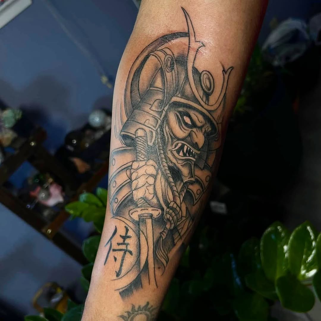 Samurai mask and sword realism tattoo on the forearm by Tattoomobile