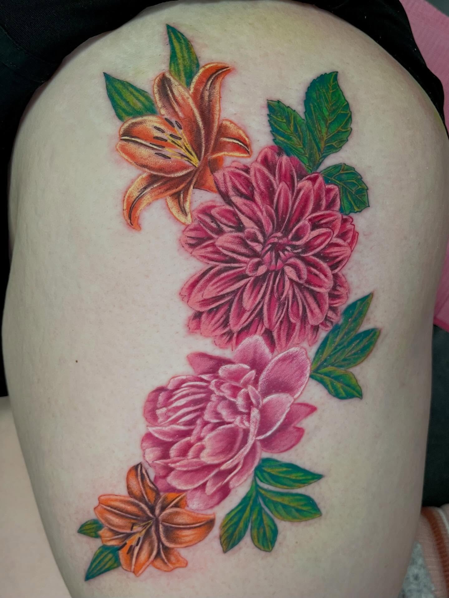 Floral arrangement realism tattoo on the thigh by Ash Wheeler