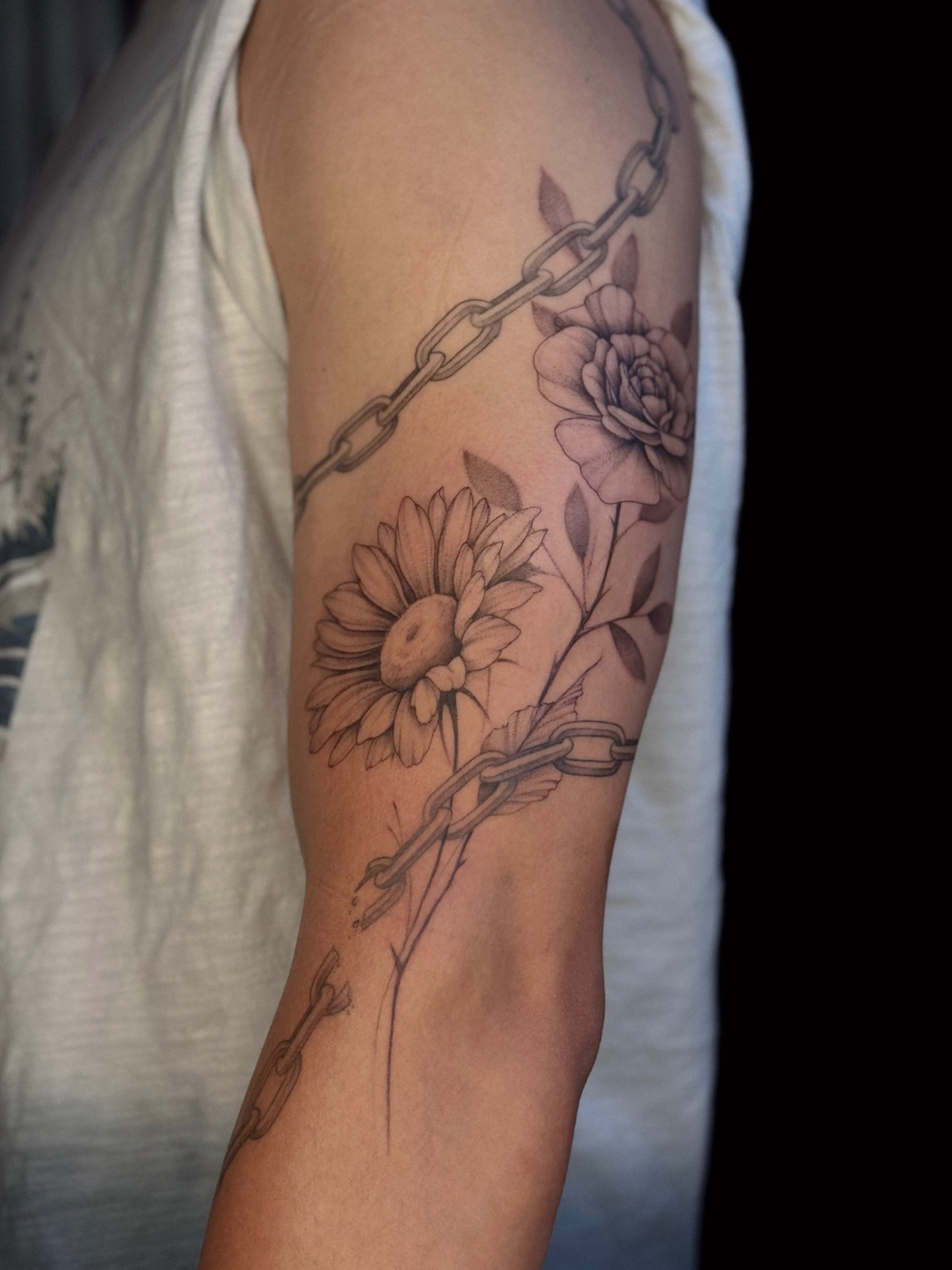 Chain and flowers realism tattoo on the forearm by Daria