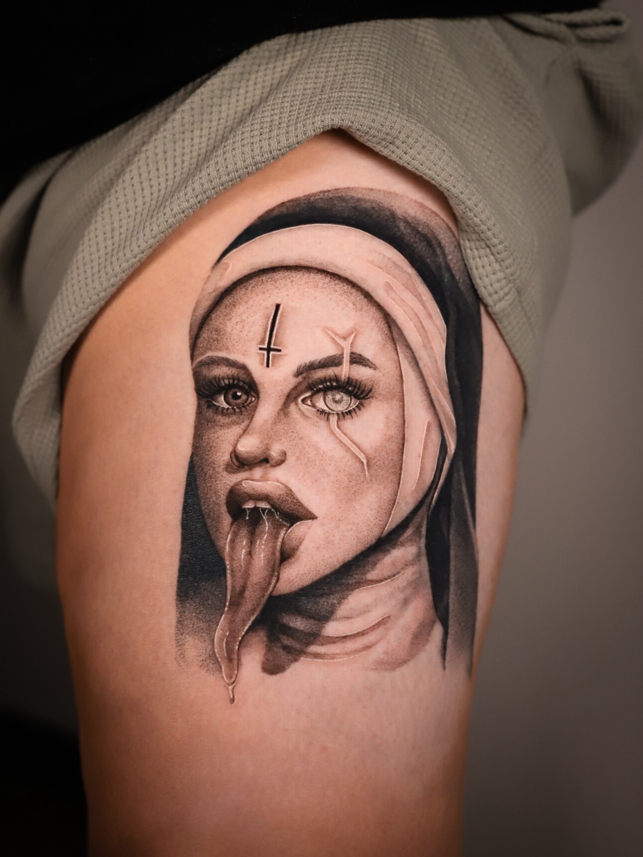 Nun with tongue out realism tattoo on the shoulder by Cyn