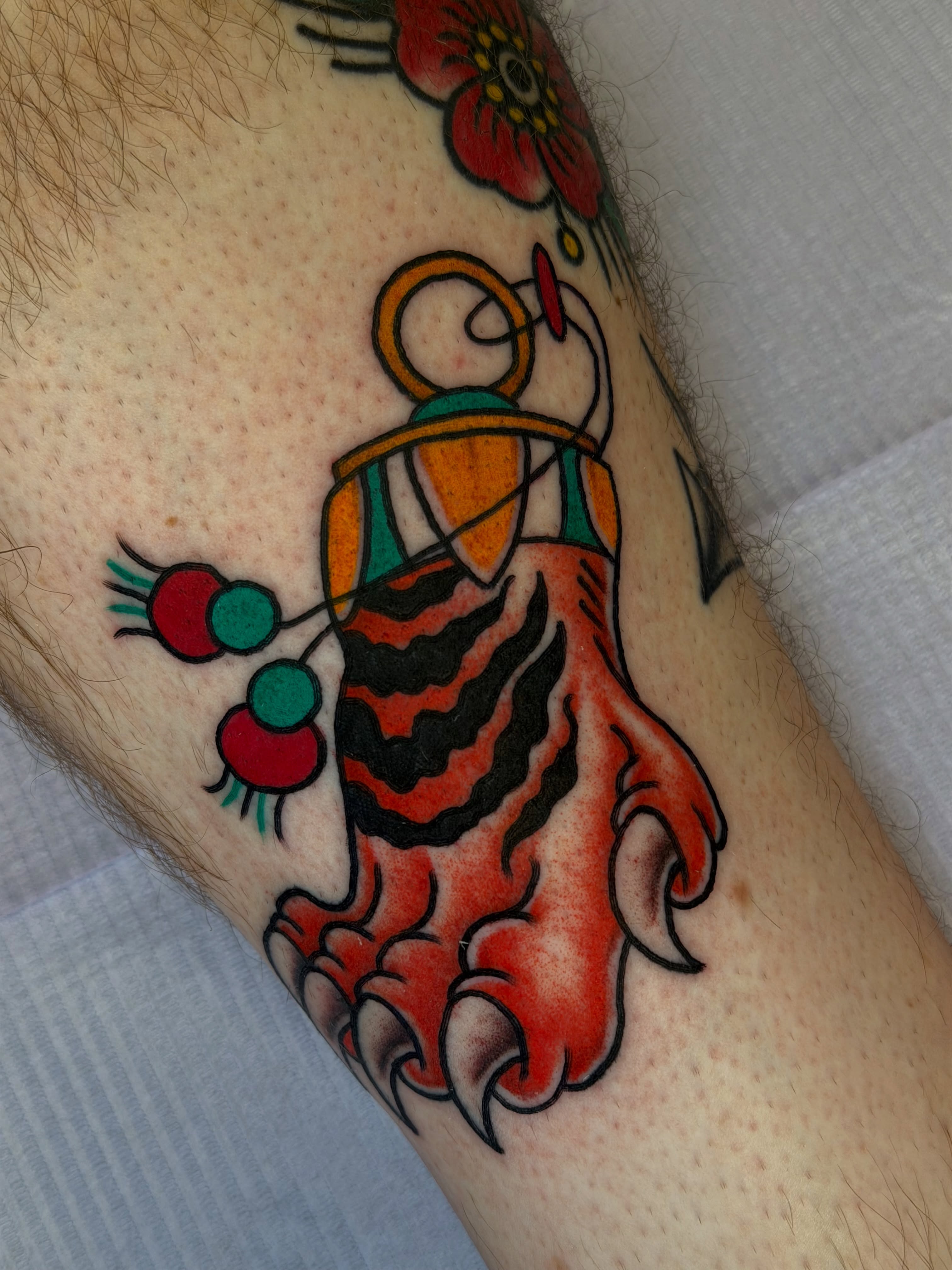 Tiger paw with cherries American traditional tattoo on the forearm by @ryanpereztattoo