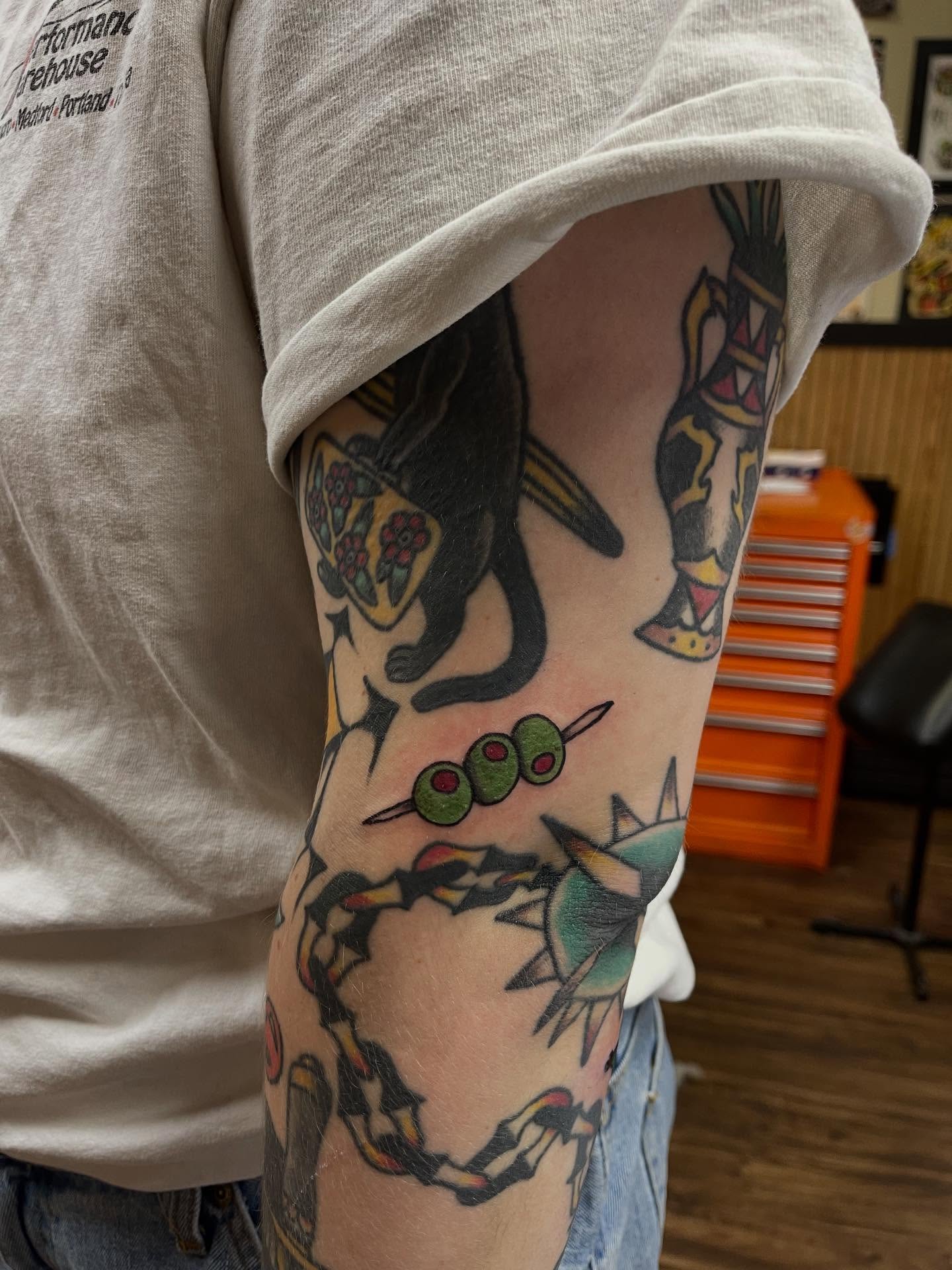 Cat and olives American traditional tattoo on the forearm by J❄️, Portland, Oregon