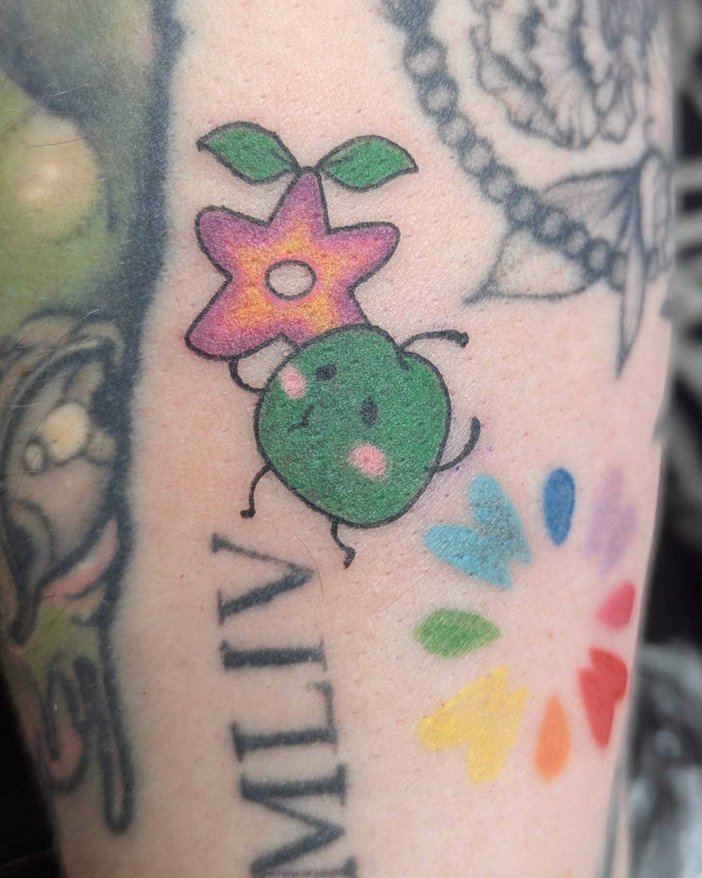 Bug with flower new school tattoo on the forearm by Spencer Jennings, Westland, Michigan