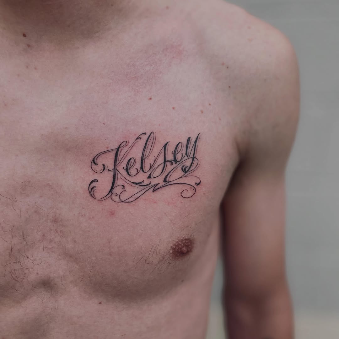 Kelsey name script lettering tattoo on the chest by Christien Xavier Alba, Salt Lake City, Utah