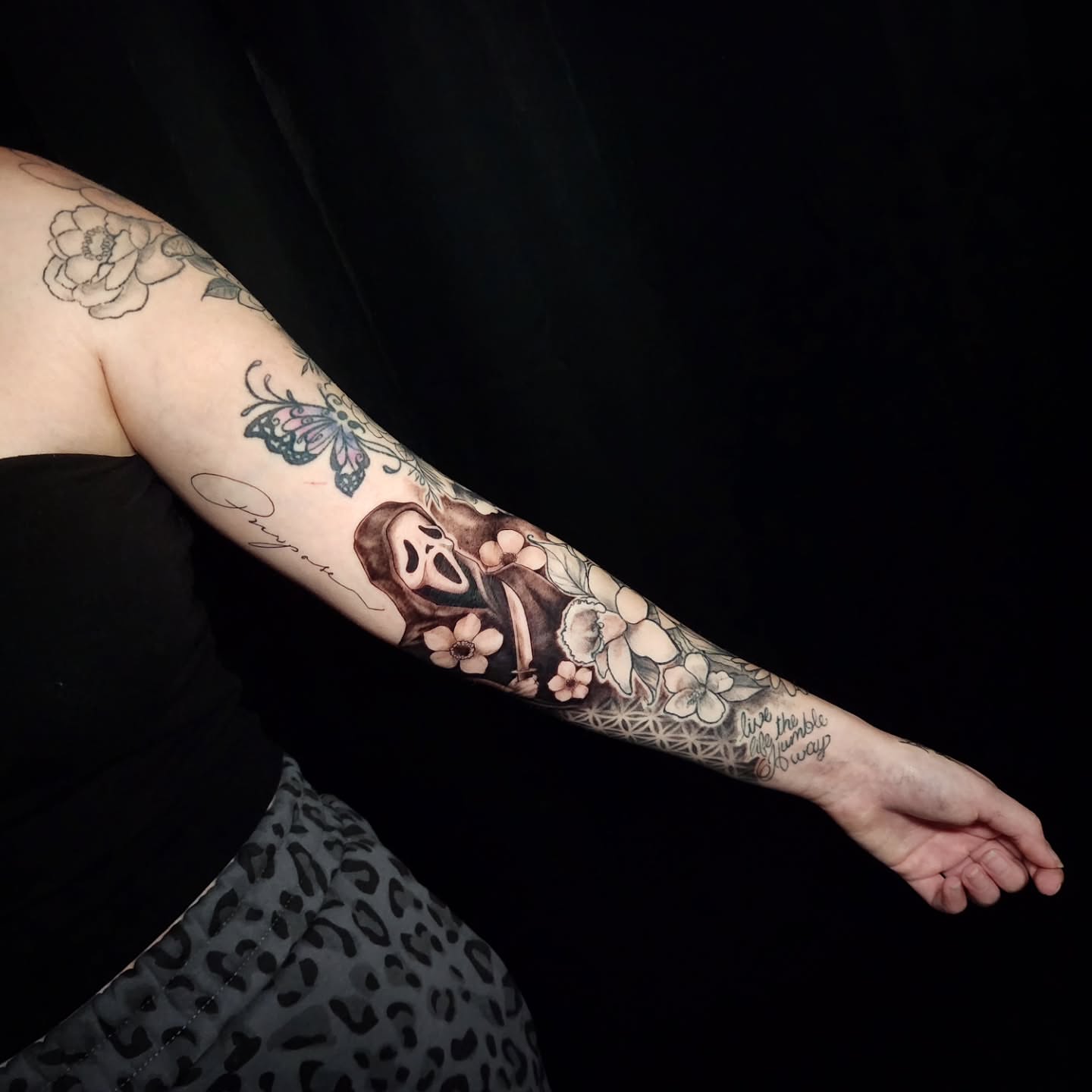 Skull and flowers geometric tattoo on the forearm by Arthur Whitney Shail